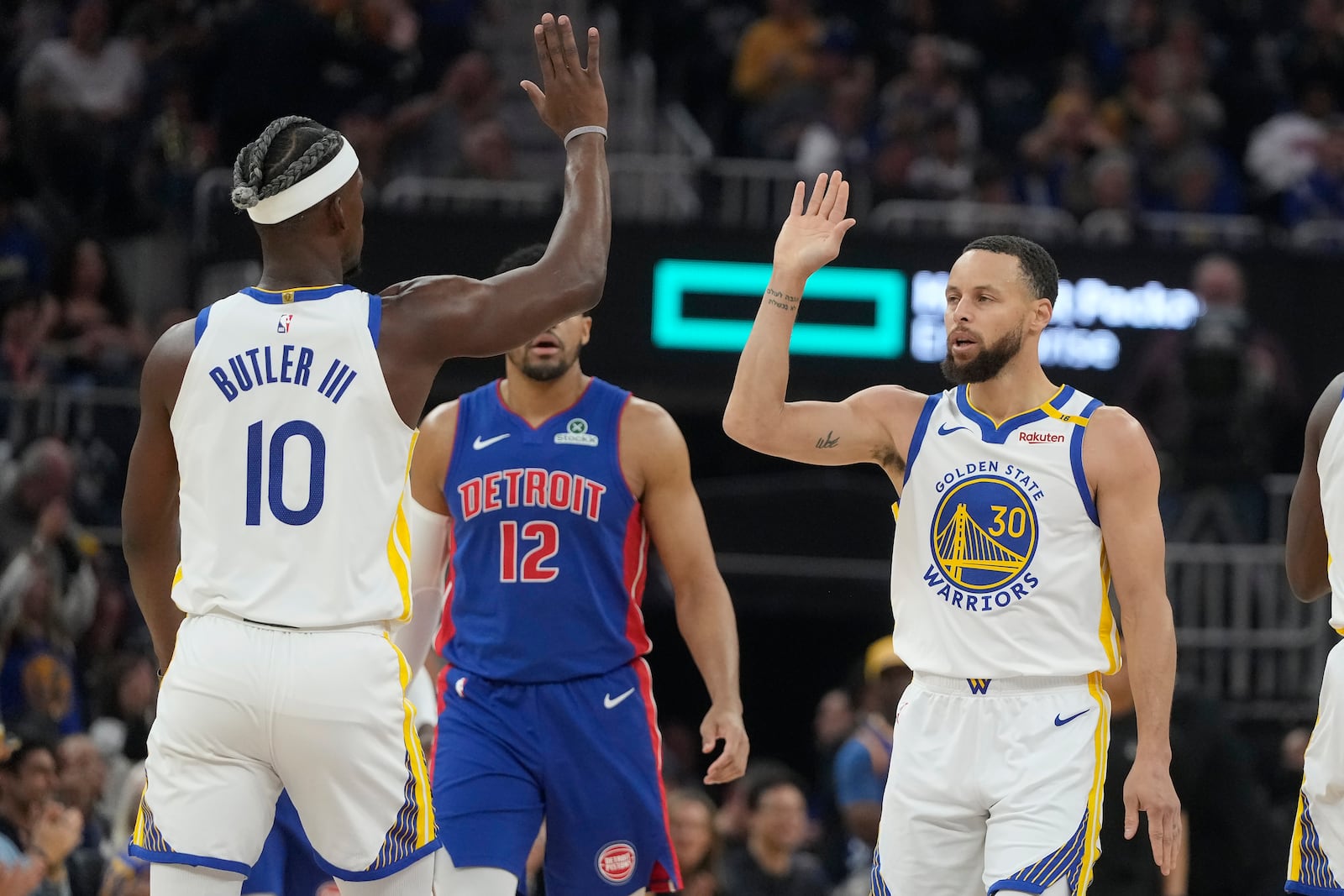 Golden State Warriors guard Stephen Curry (30) is congratulated by forward Jimmy Butler III (10) after making a three-point basket during the first half of an NBA basketball game against the Detroit Pistons in San Francisco, Saturday, March 8, 2025. (AP Photo/Jeff Chiu)