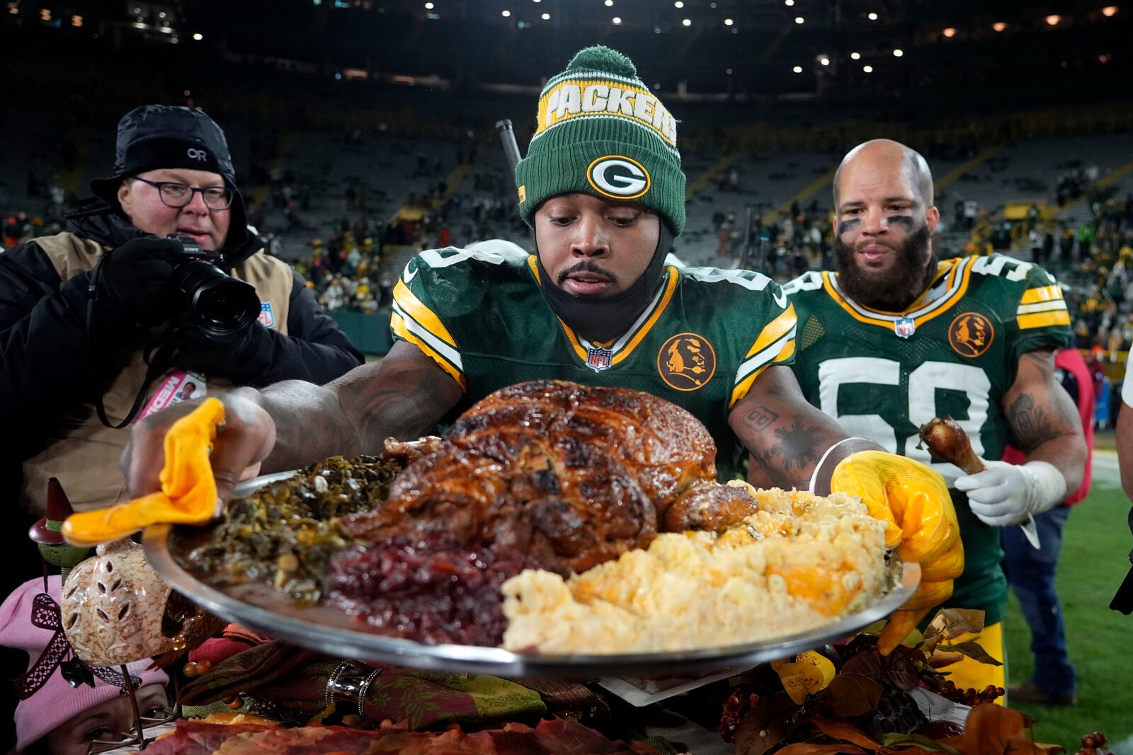 Green Bay Packers running back Josh Jacobs (8) holds a plate of turkey after an NFL football game against the Miami Dolphins Thursday, Nov. 28, 2024, in Green Bay, Wis. (AP Photo/Morry Gash)