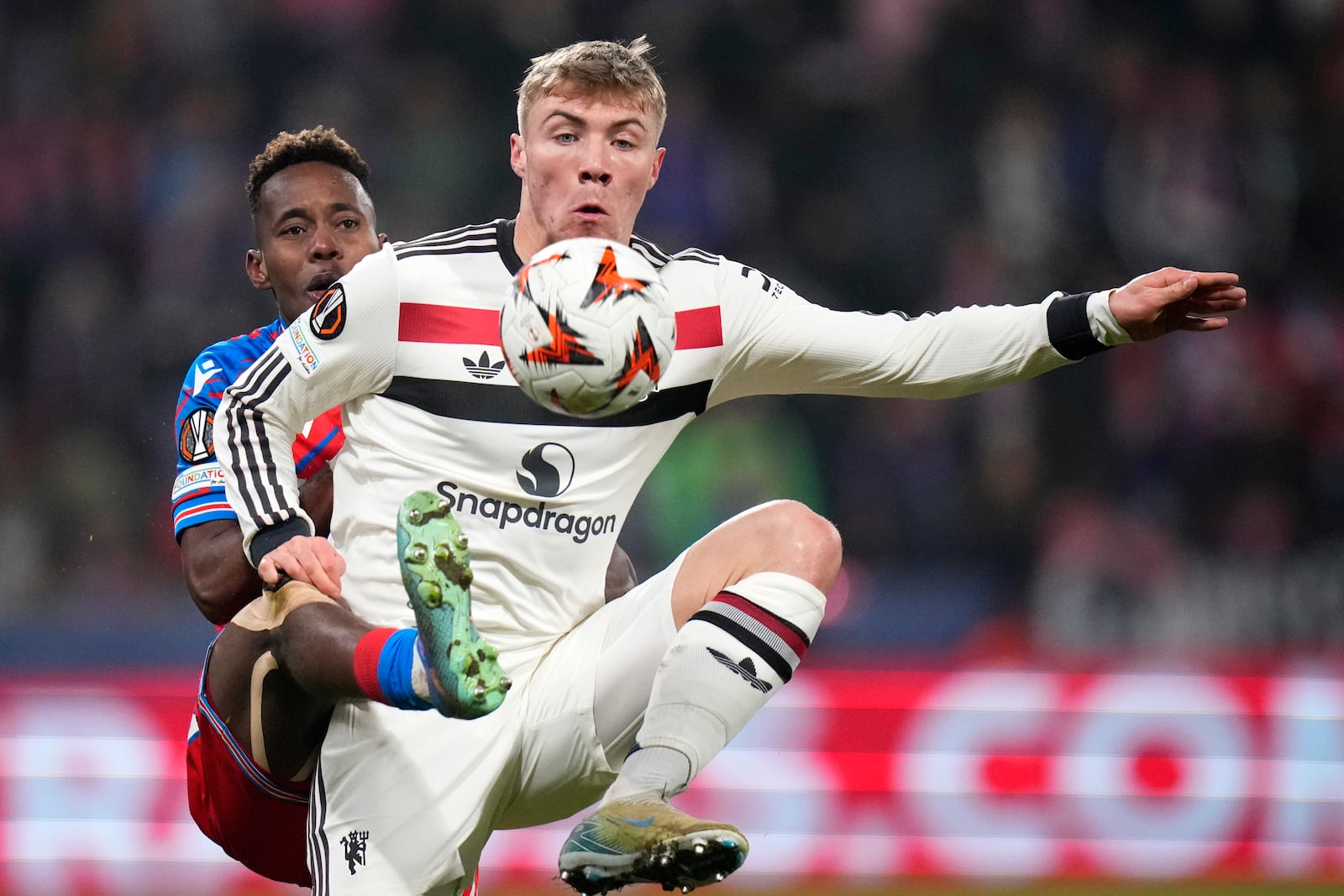 Manchester United's Rasmus Hojlund, right, challenges for the ball with Plzen's Sampson Dweh during the Europa League soccer match between Viktoria Plzen and Manchester United at the Doosan Arena in Plzen, Czech Republic, Thursday, Dec. 12, 2024. (AP Photo/Petr David Josek)