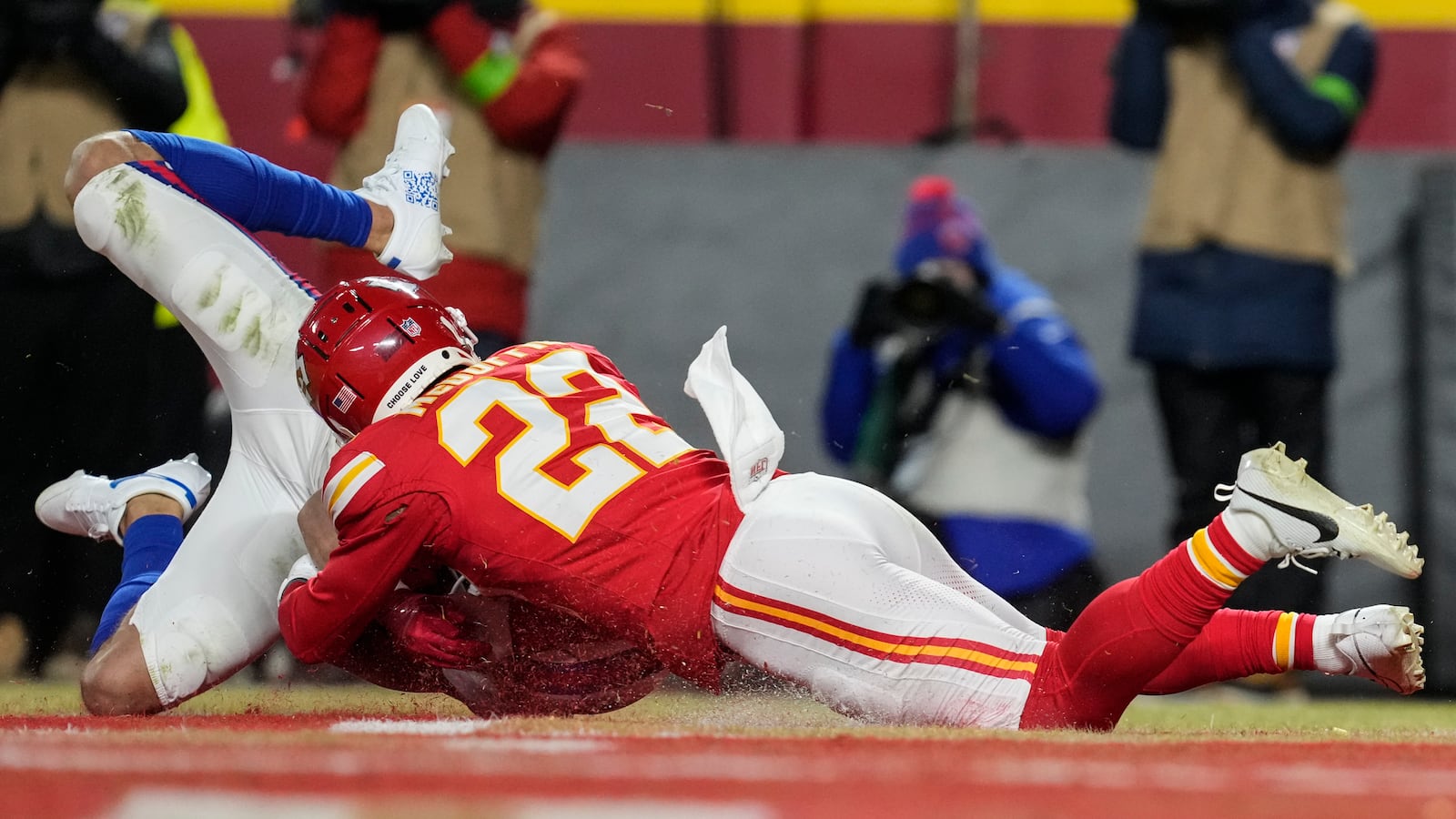 Kansas City Chiefs cornerback Trent McDuffie (22) tackles Buffalo Bills wide receiver Mack Hollins (13) after Hollins scored a touchdown during the first half of the AFC Championship NFL football game, Sunday, Jan. 26, 2025, in Kansas City, Mo. (AP Photo/Ashley Landis)