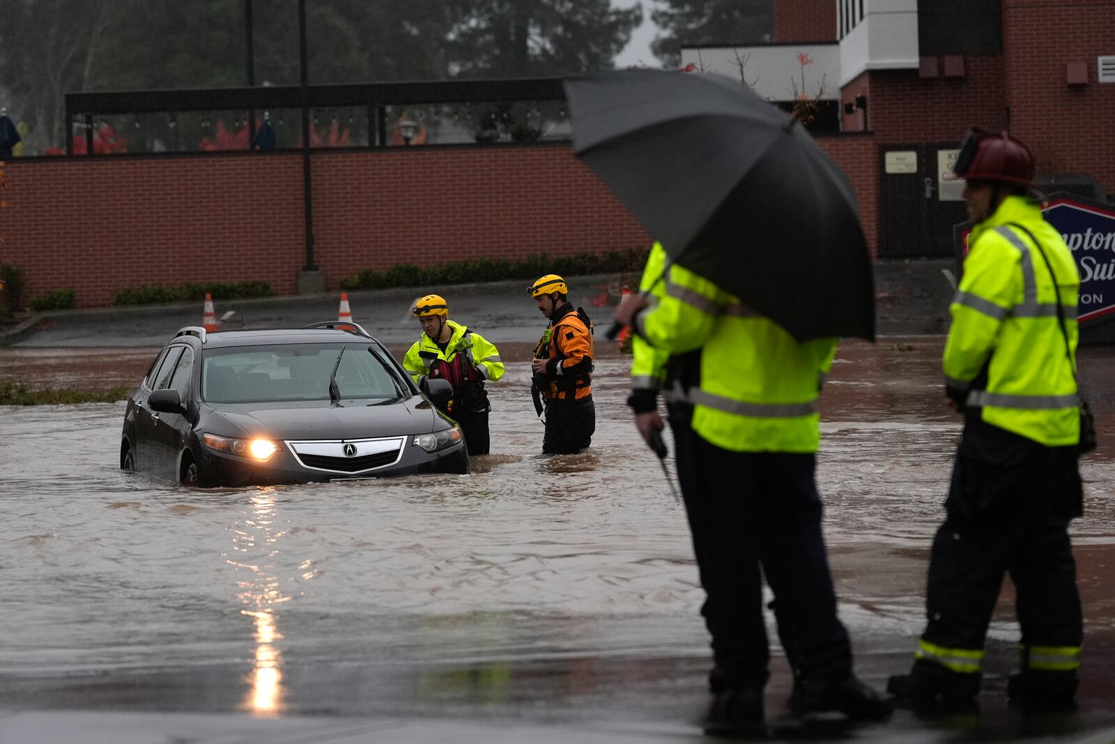 A rescue team help a stranded motorist in a flooded street during a storm Thursday, Nov. 21, 2024, in Santa Rosa, Calif. (AP Photo/Jeff Chiu)