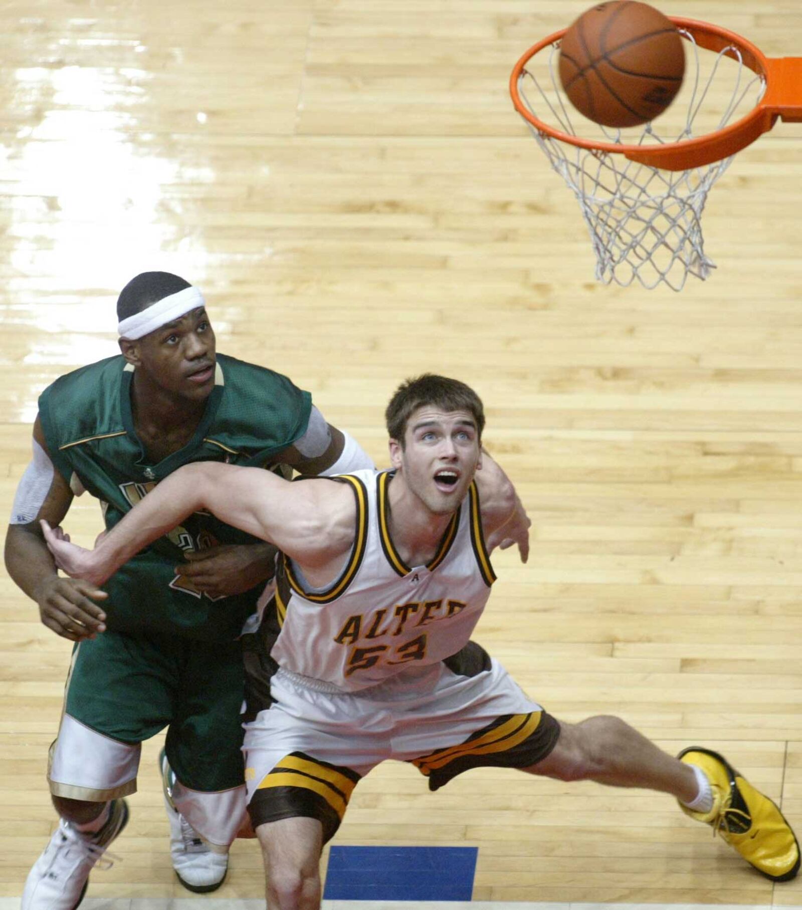 In this 2003 file photo: Adam Gill (53), of Alter, boxes out Lebron James, as they look for a rebound. Alter played St. Vincent/St.Mary at the University of Dayton Arena.