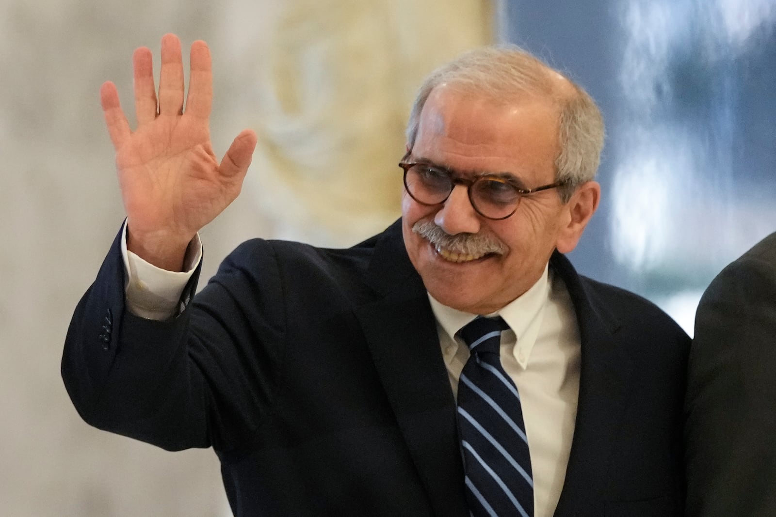 Lebanese Prime Minister-designate Nawaf Salam waves to journalists as he arrives at the presidential palace to meet with Lebanese President Joseph Aoun in Baabda, in east of Beirut, Lebanon, Tuesday, Jan. 14, 2025. (AP Photo/Hassan Ammar)