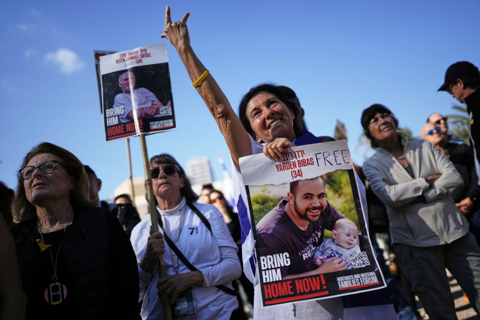 Israelis react as they watch a broadcast of the release of American-Israeli Keith Siegel, as he is released as part of a ceasefire in the Gaza Strip, in Tel Aviv, Israel, Saturday Feb. 1, 2025. (AP Photo/Oded Balilty)