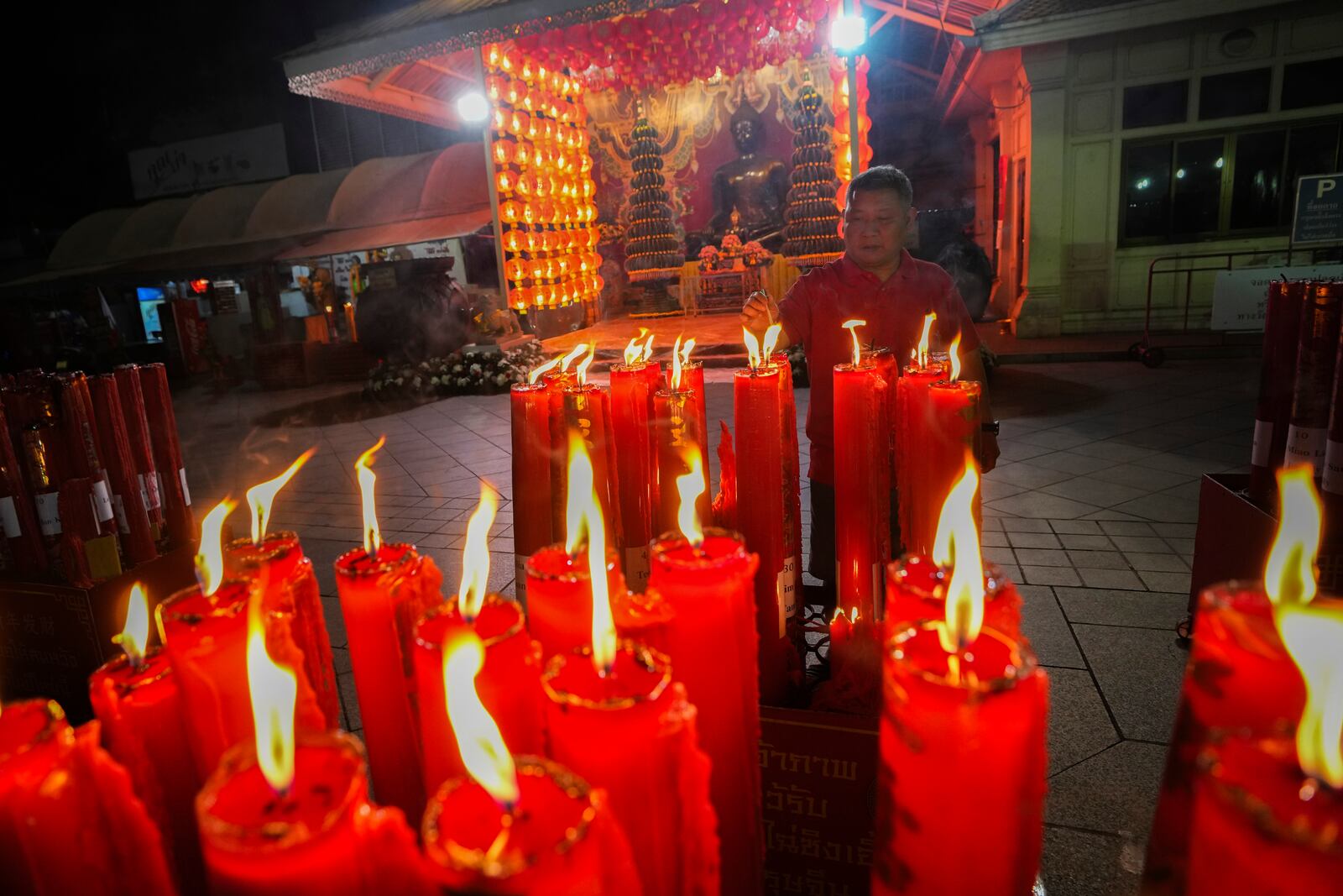 An Ethnic Chinese Thai lights joss sticks at Trai Mit Temple to celebrate the Lunar New Year in Bangkok, Thailand, Wednesday, Jan. 29, 2025. (AP Photo/Sakchai Lalit)