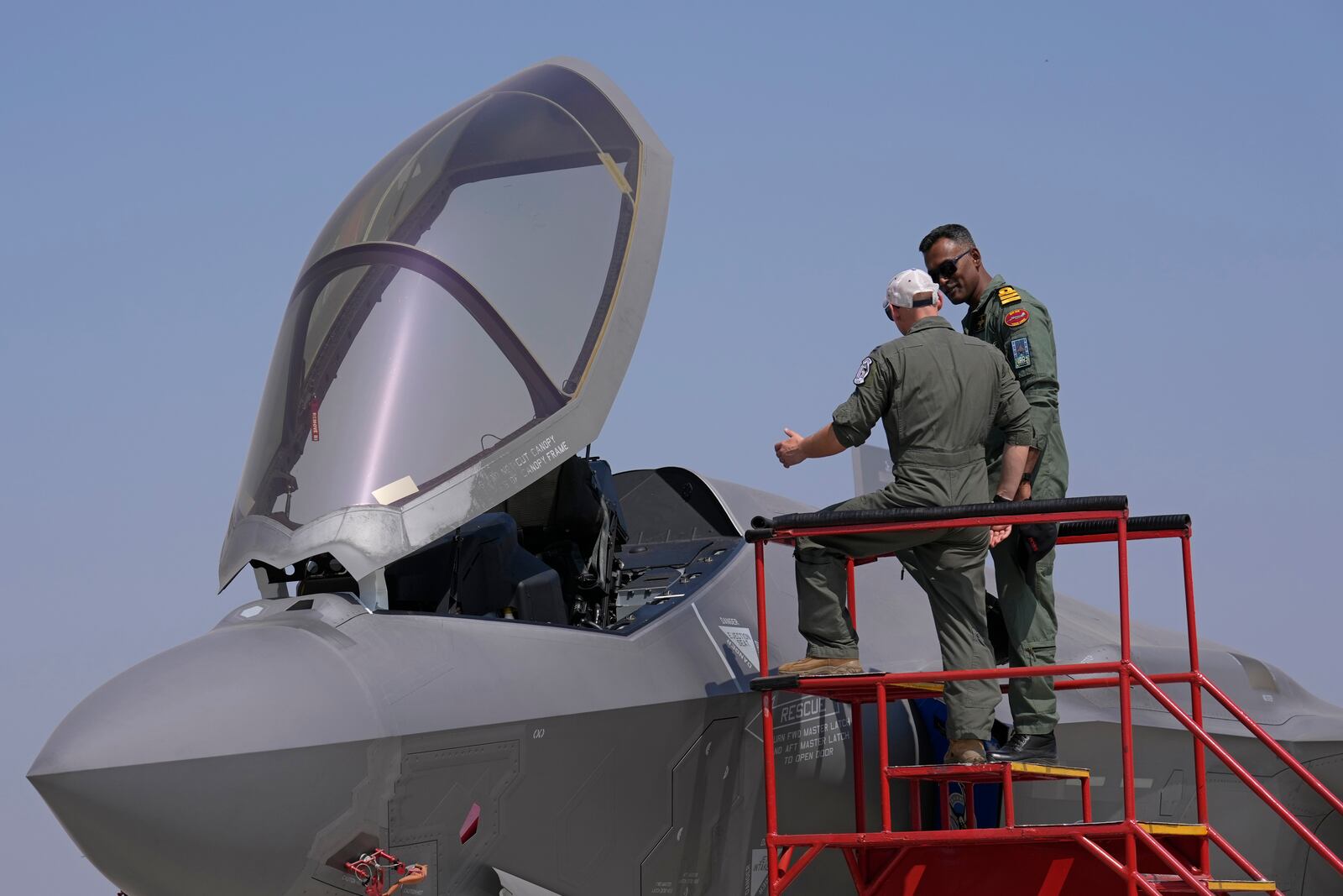 A U.S. Air Force officer, left, briefs an Indian naval officer about the F-35 fighter aircraft at the static display area on the last day of the Aero India 2025, a biennial event, at Yelahanka air base in Bengaluru, India, Friday, Feb. 14, 2025. (AP Photo/Aijaz Rahi)