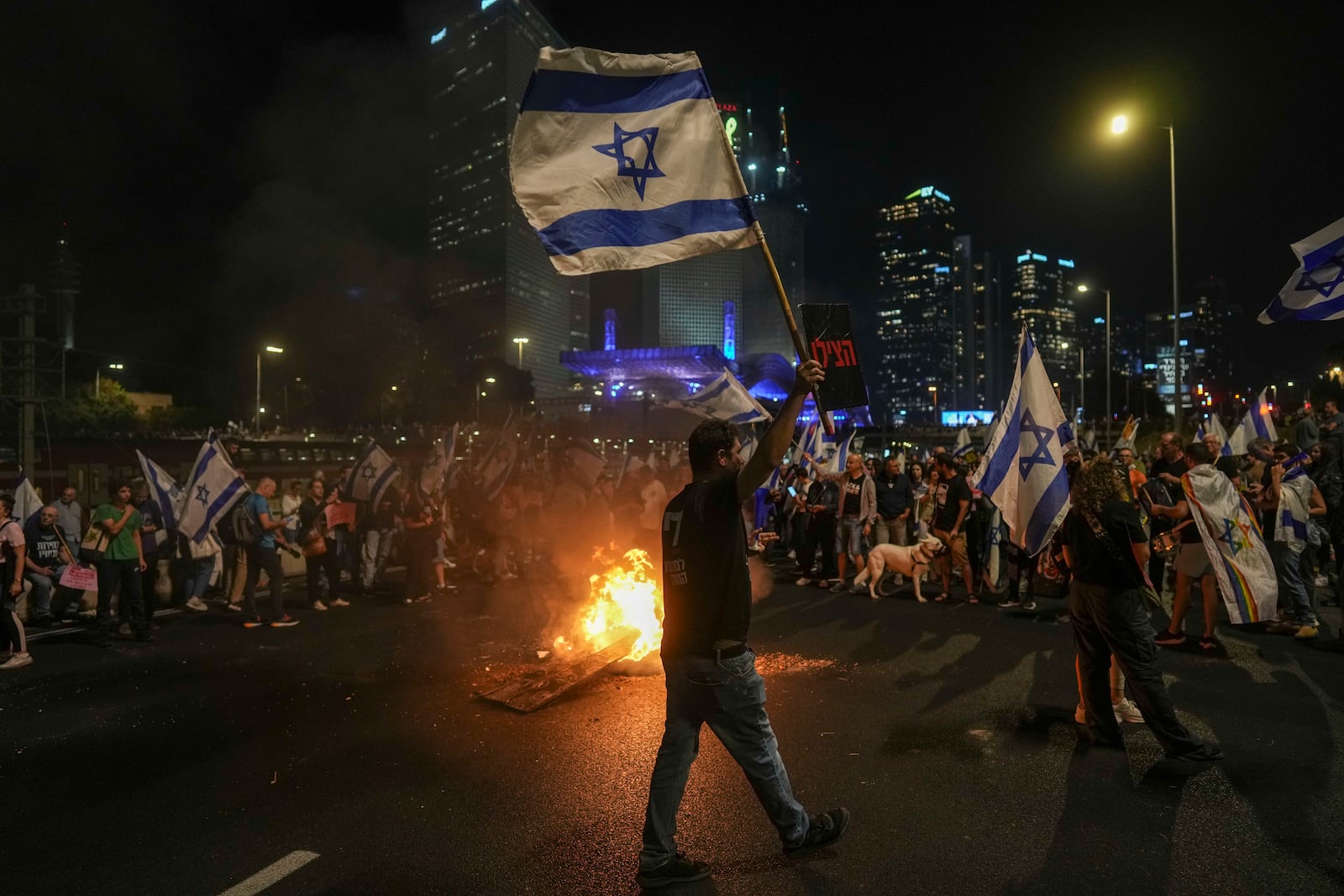 Israelis light a bonfire during a protest after Prime Minister Benjamin Netanyahu has dismissed his popular defense minister, Yoav Gallant, in a surprise announcement in Tel Aviv, Israel, Tuesday, Nov. 5, 2024. (AP Photo/Oded Balilty)