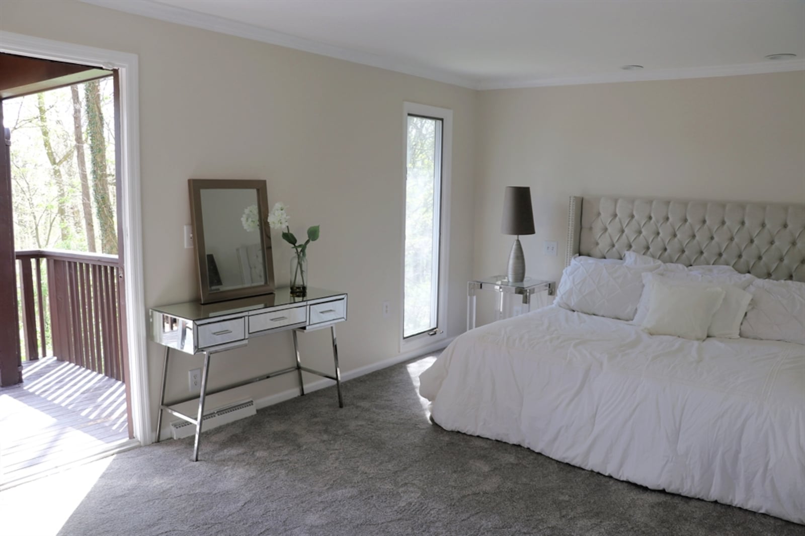 Large sliding patio doors in the primary bedroom open out to a covered balcony deck. 