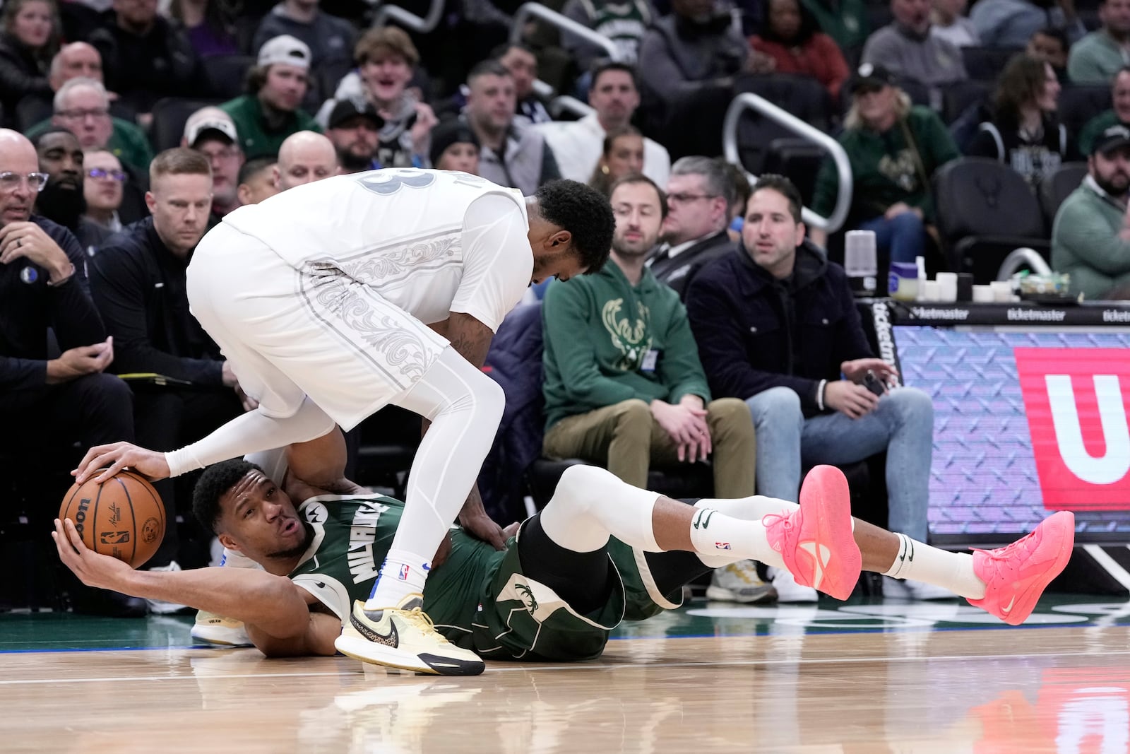 Milwaukee Bucks' Giannis Antetokounmpo and Dallas Mavericks' Naji Marshall battle for a loose ball during the first half of an NBA basketball game Wednesday, March 5, 2025, in Milwaukee. (AP Photo/Morry Gash)