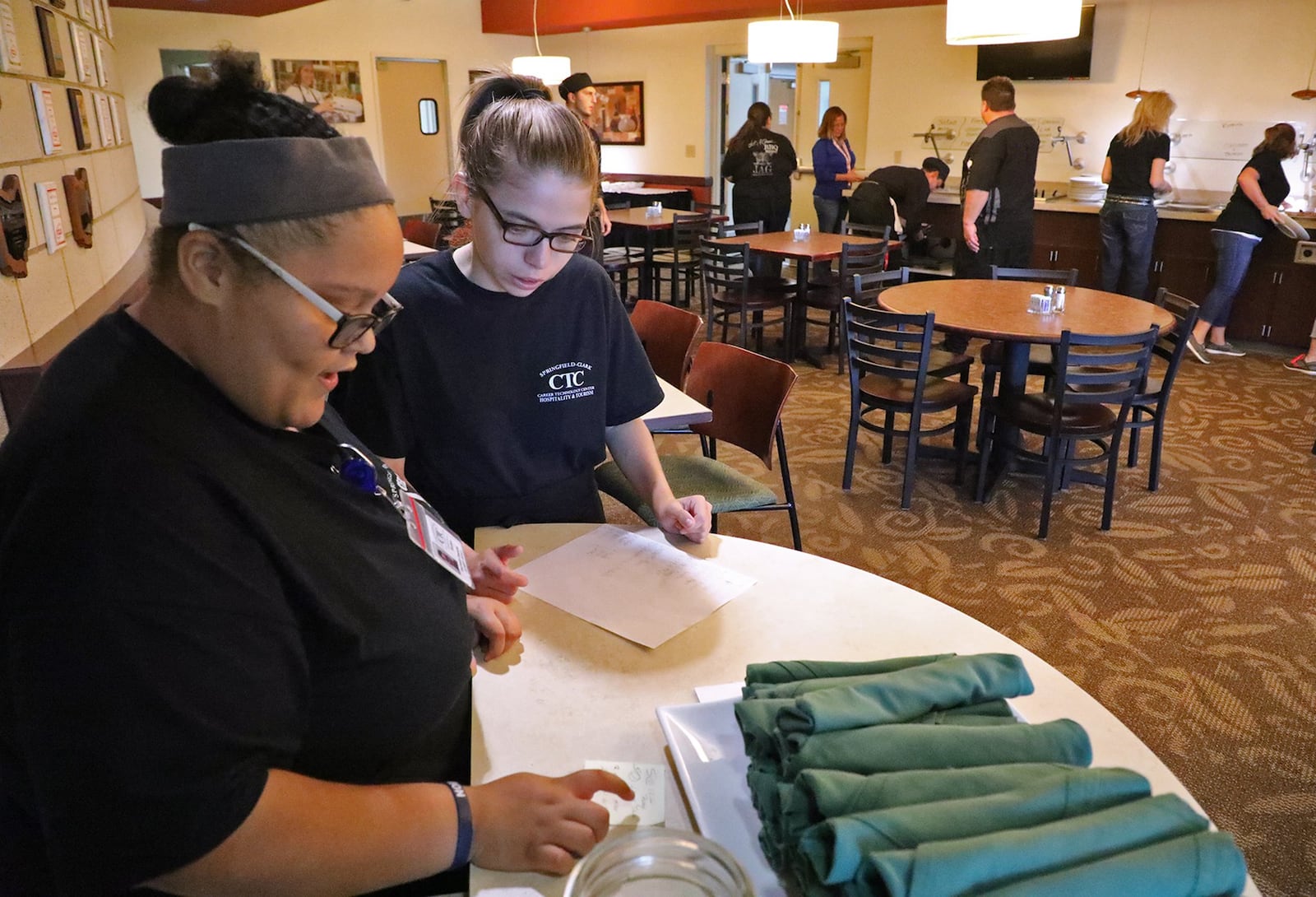 Students Mychaela Dawkins (left) and Breanna Nelson figure at seating and schedules at the hostess counter at the Jaguar Room. BILL LACKEY/STAFF