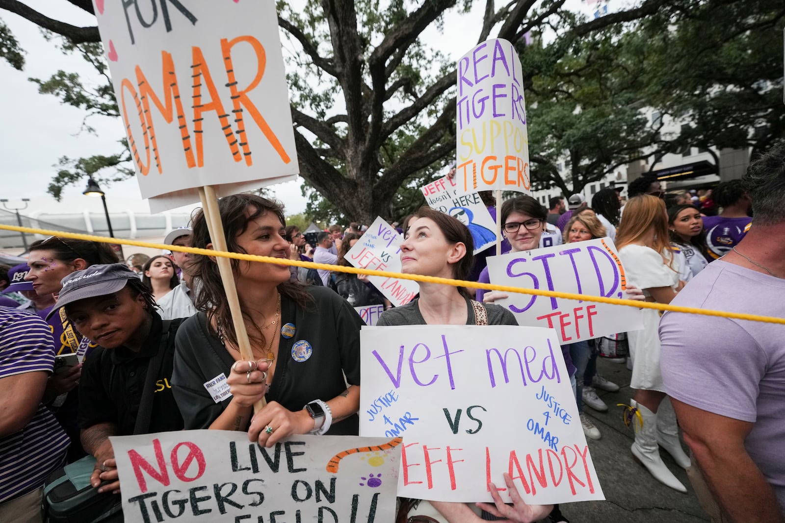 Haley Betz, Lauren Hausey and Camille Evans, veterinary technicians, protest the use of plans to use a live tiger as a mascot in the stadium, before an NCAA college football game between LSU and Alabama in Baton Rouge, La., Saturday, Nov. 9, 2024. (AP Photo/Gerald Herbert)