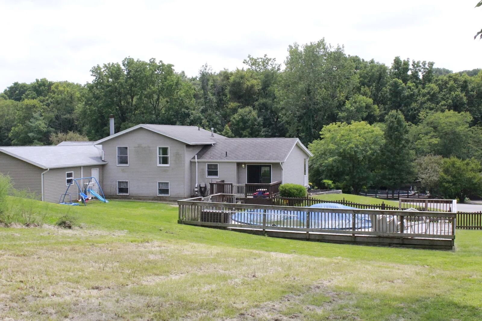 The rear of the home features an above-ground swimming pool with wood deck, wood deck attached to the house with railing and wood picket fence surrounding the yard. Contributed 