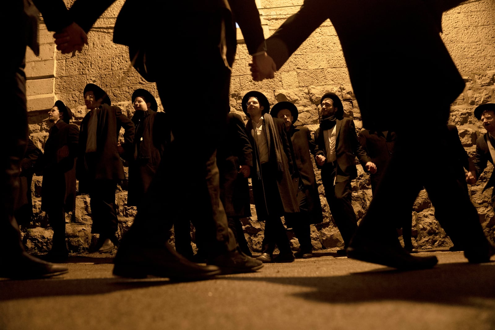 Ultra-Orthodox Jewish yeshiva students dance after lighting candles to mark the holiday of Hanukkah in Jerusalem, Wednesday, Jan. 1, 2025. (AP Photo/Maya Alleruzzo)