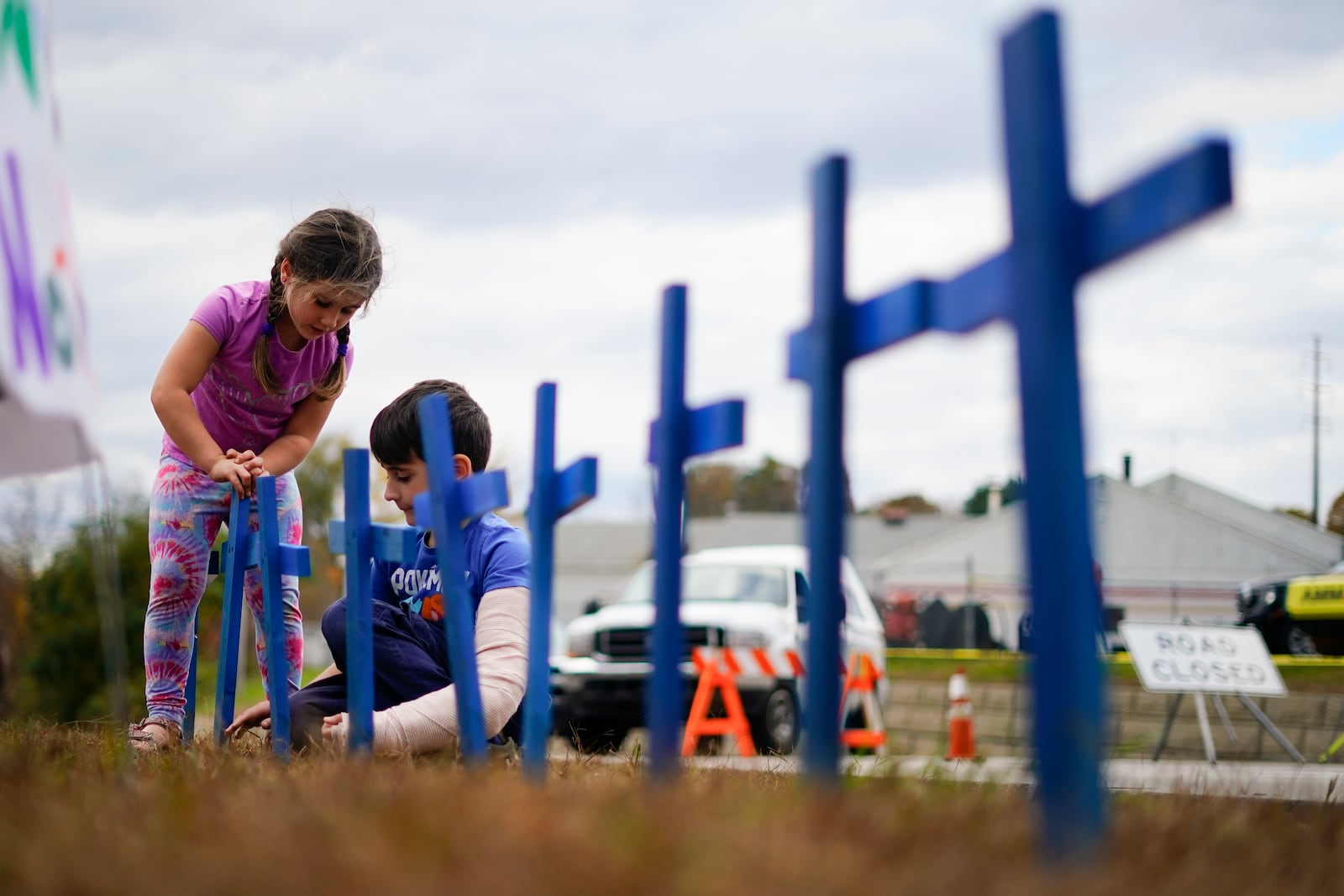 FILE - Lucy Allard, 5, and her brother Zeke Allard, 8, plant crosses in honor of the victims of this week's mass shooting in Lewiston, Maine, Oct. 28, 2023. (AP Photo/Matt Rourke)