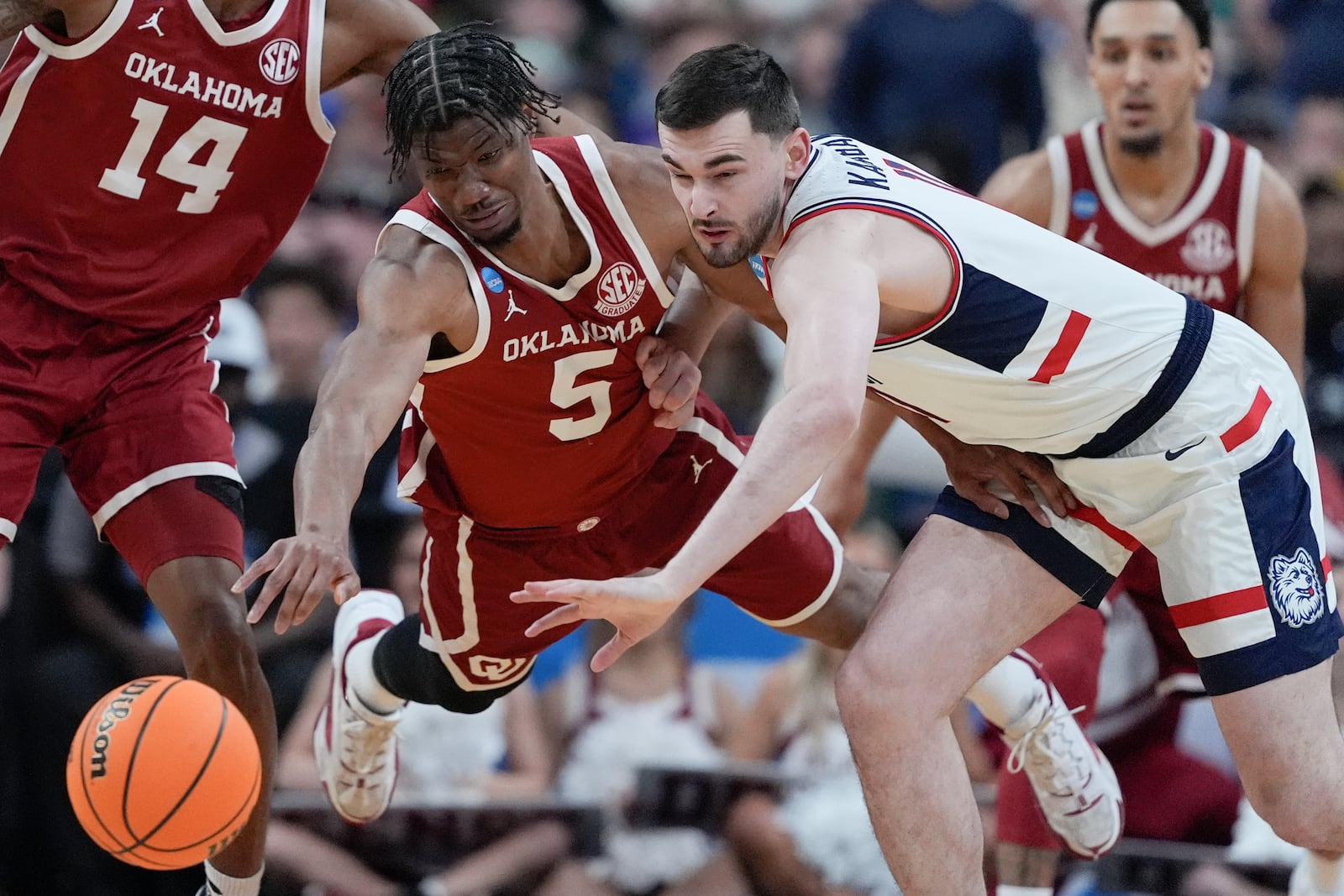 Oklahoma forward Mohamed Wague, left, vies for a loose ball with UConn forward Alex Karaban during the first half in the first round of the NCAA college basketball tournament, Friday, March 21, 2025, in Raleigh, N.C. (AP Photo/Chris Carlson)