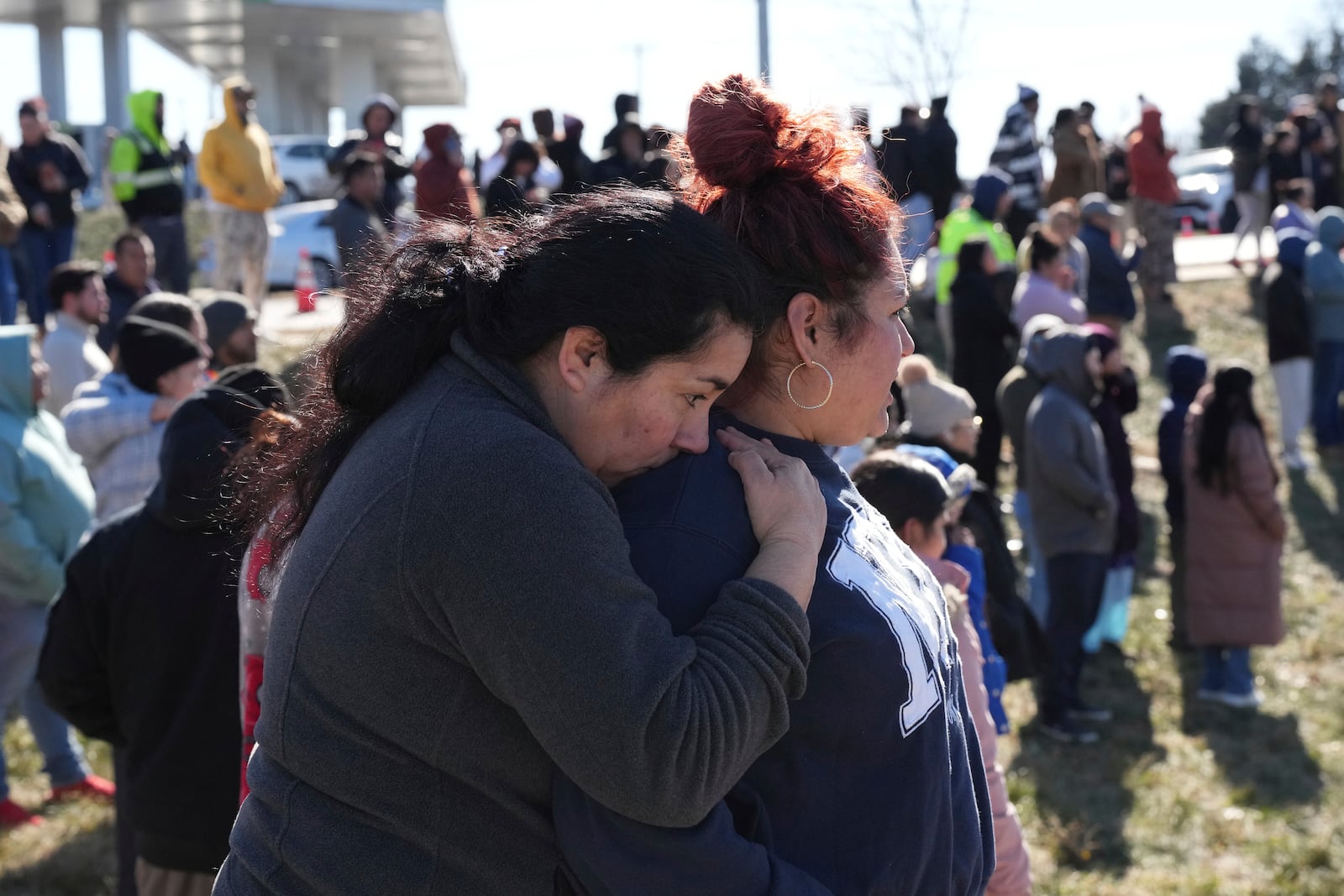 People wait as school buses arrive at a unification site following a shooting at the Antioch High School in Nashville, Tenn., Wednesday, Jan. 22, 2025. (AP Photo/George Walker IV)