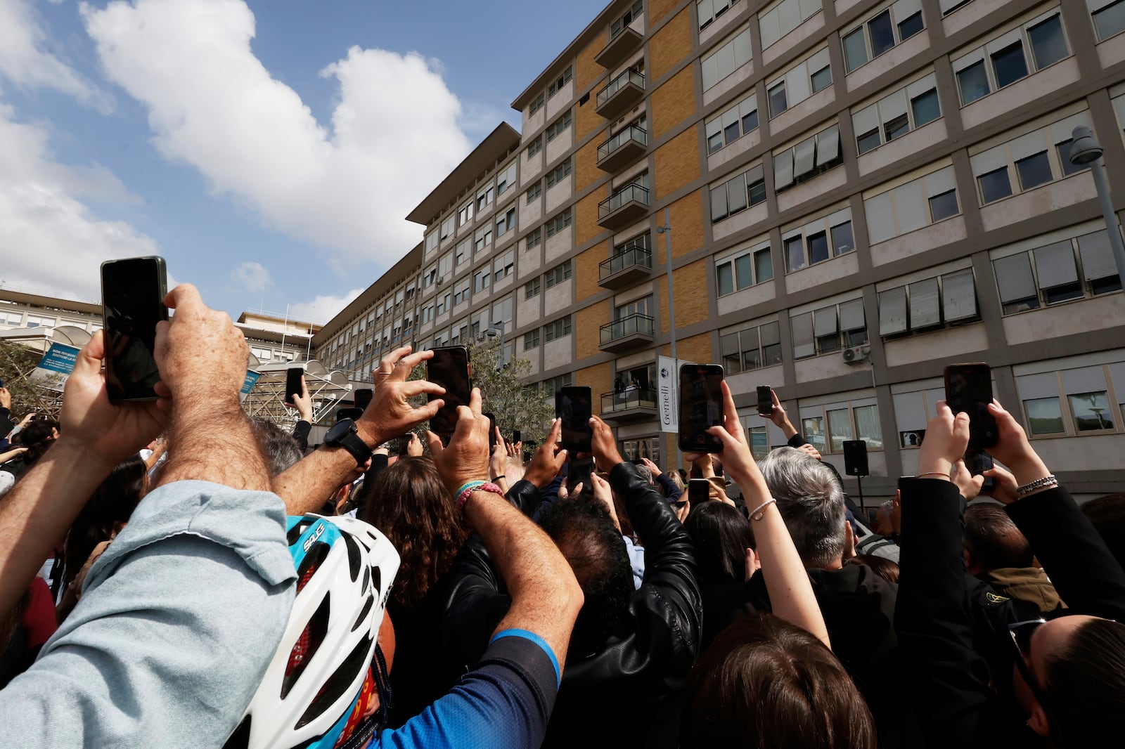 Faithfuls wait a Pope Francis appearing at a window of the Agostino Gemelli Polyclinic in Rome, Sunday, March 23, 2025, for the first time after being admitted on Feb. 14 with bronchitis that afterward worsened into bilateral pneumonia. (AP Photo/Riccardo De Luca)