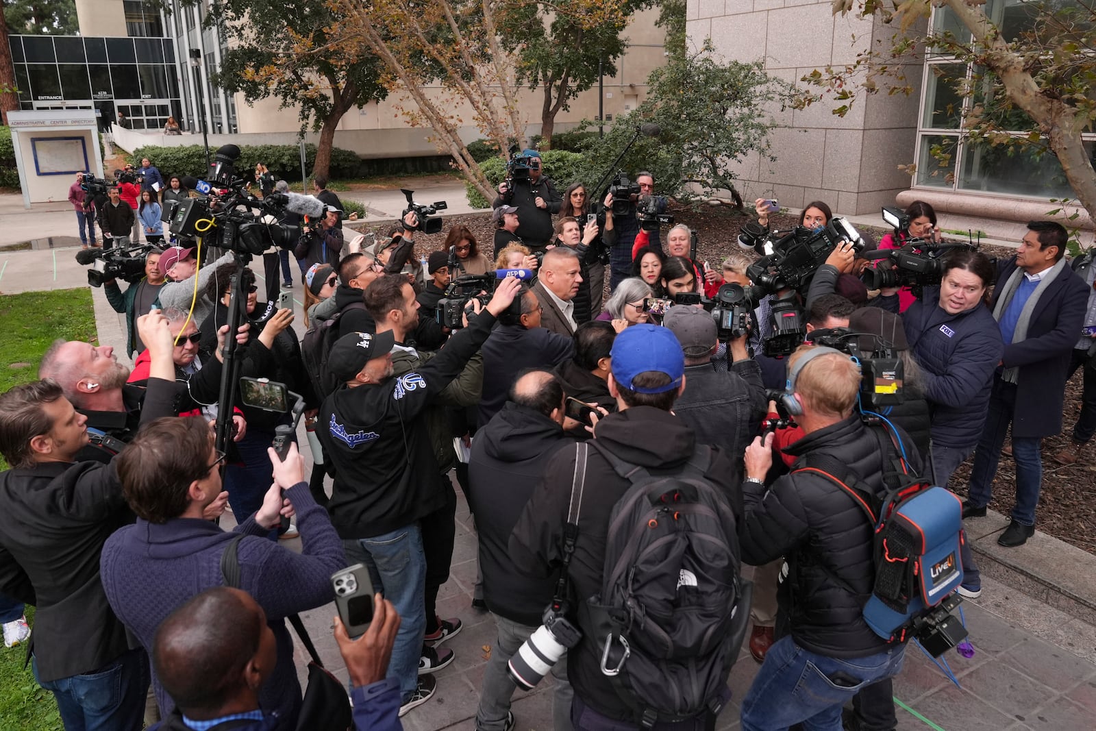 The media surround family members of the Erik and Lyle Menendez brothers as they arrive at a courthouse to attend a hearing in Los Angeles, Monday, Nov. 25, 2024. (AP Photo/Jae C. Hong)