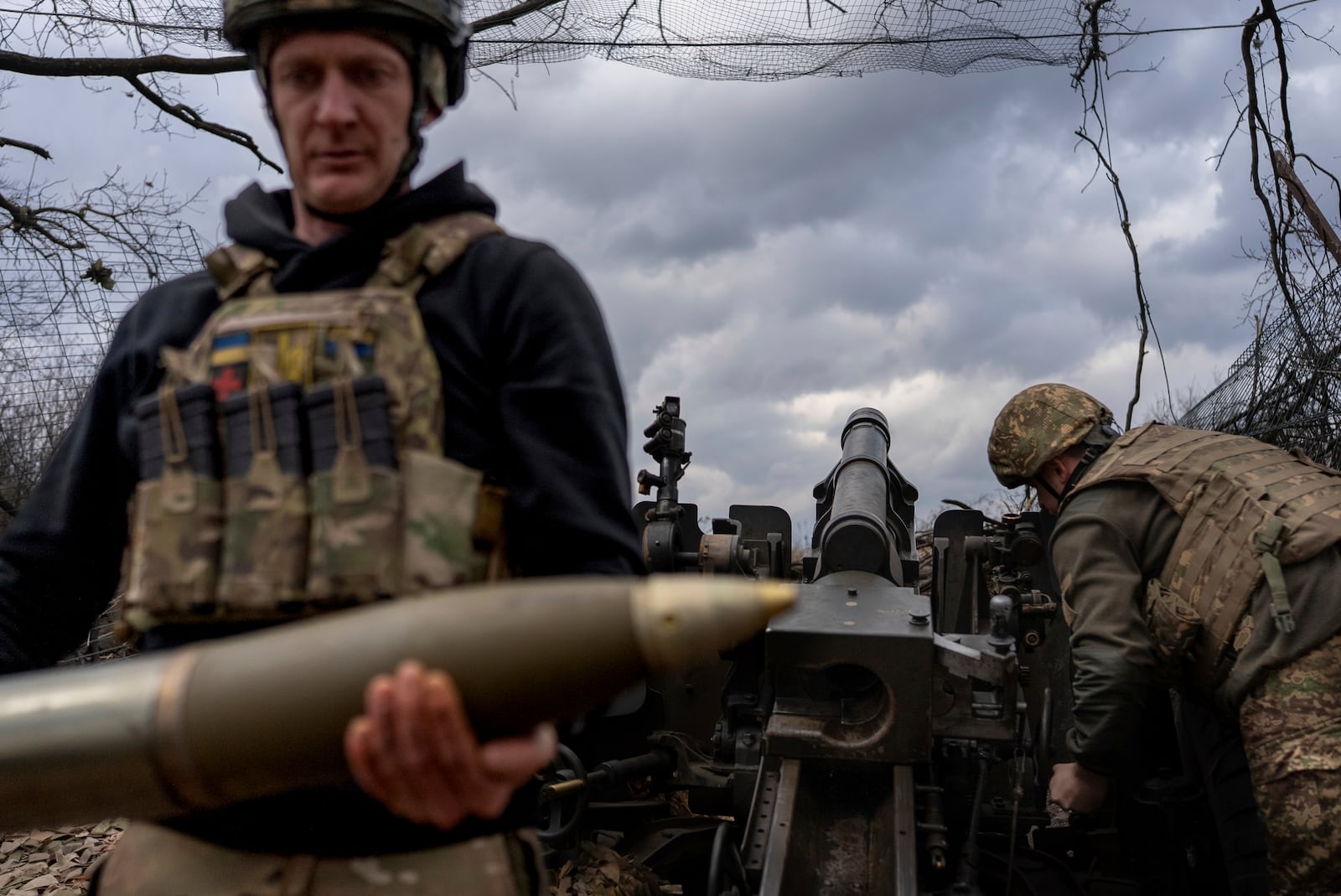 Ukrainian servicemen of Khartia brigade are preparing M101 Howitzer before firing towards Russian positions in Kharkiv region, Ukraine, Wednesday, March 12, 2025. (AP Photo/Alex Babenko)