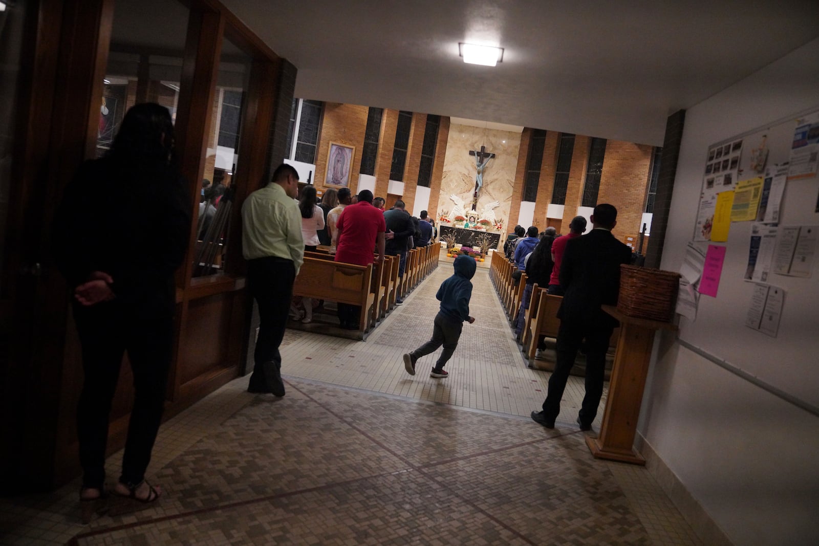 A young boy runs back to his pew during the Spanish-language Mass at St. Mary’s Catholic Church on Saturday, Oct. 19, 2024, in Worthington, Minn. (AP Photo/Jessie Wardarski)