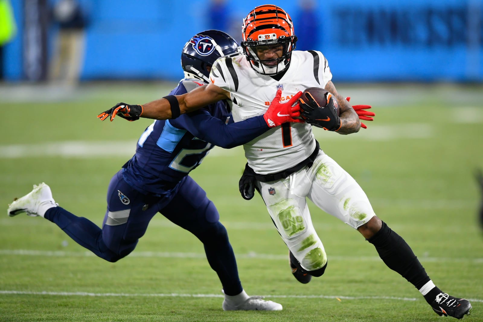 Tennessee Titans cornerback Janoris Jenkins (20) tackles Cincinnati Bengals wide receiver Ja'Marr Chase (1) during the second half of an NFL divisional round playoff football game, Saturday, Jan. 22, 2022, in Nashville, Tenn. (AP Photo/John Amis)