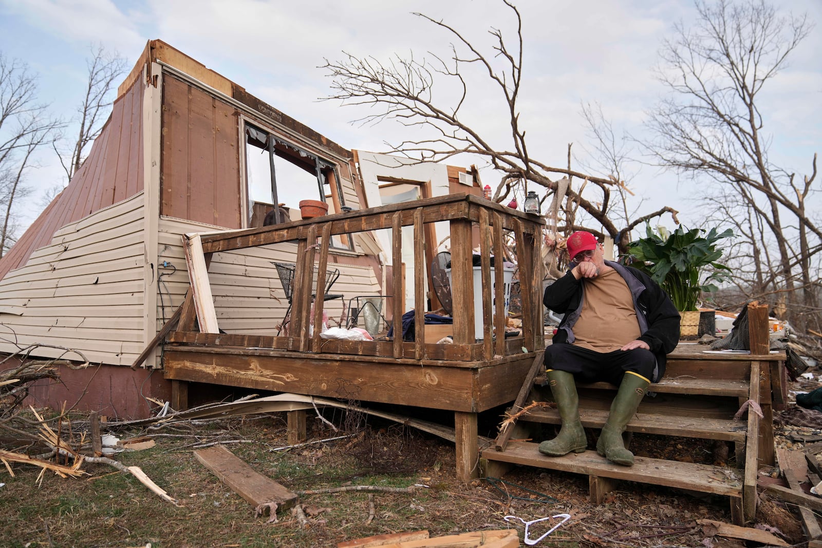 Tim Scott sits on the stairs of his home he was inside when it was destroyed during a severe storm the evening before Saturday, March 15, 2025, in Wayne County, Mo. (AP Photo/Jeff Roberson)