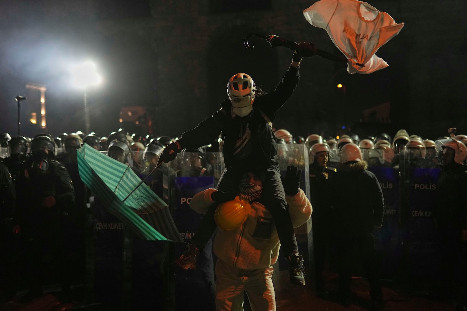 Protesters stand in front of riot police as they protest against the arrest of Istanbul's Mayor Ekrem Imamoglu, in Istanbul, Turkey, Saturday, March 22, 2025. (AP Photo/Francisco Seco)