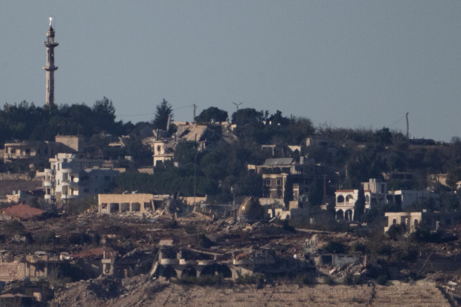 Destroyed buildings stand in an area in southern Lebanon as seen from northern Israel, Tuesday, Oct. 8, 2024. (AP Photo/Leo Correa)