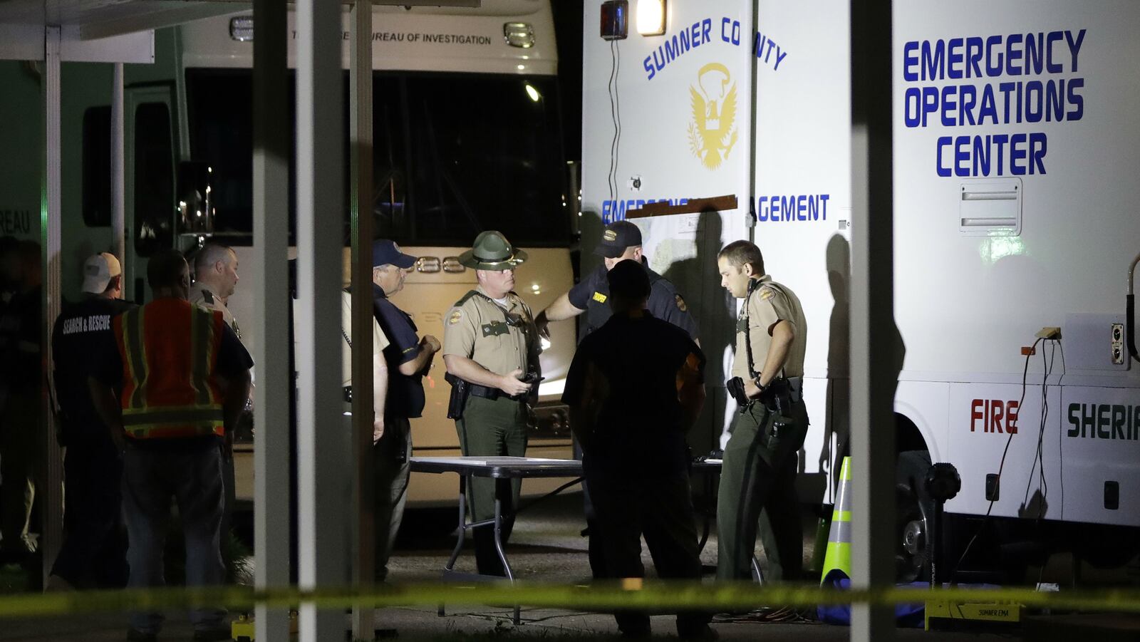 Law enforcement officials work at a command center set up at North Sumner Elementary School Saturday, April 27, 2019, in Bethpage, Tenn., as they search for homicide suspect Michael Lee Cummins. Cummins, 25, of Westmoreland, Tennessee, is accused of killing six people found beaten to death in their home Saturday, April 27, 2019, including his parents, uncle and a 12-year-old girl. Cummins is also charged in the death of a seventh person found beaten to death in her home that same day, as well as that of a man whose headless body was found near his cabin just outside Westmoreland April 17, 2019.