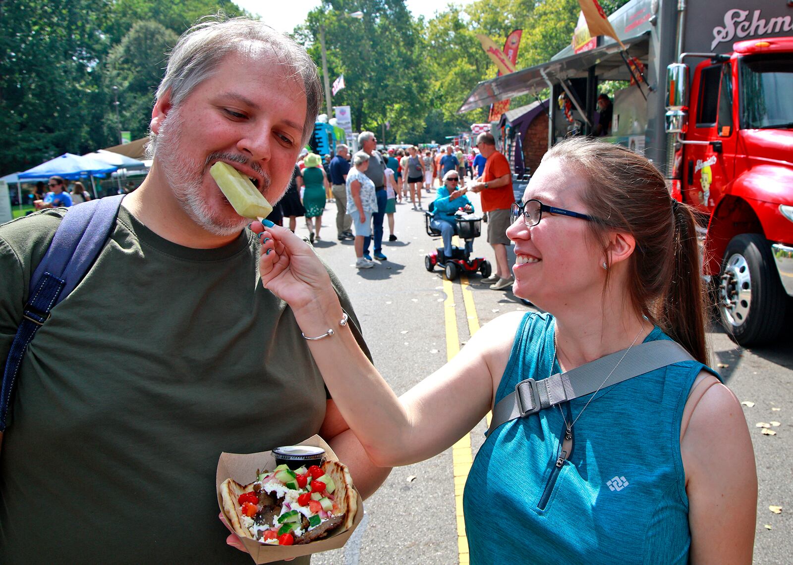 Erin Christian shares her frozen fruit bar Mark Brooks Saturday, August 17, 2024 at the 10th annual Springfield Rotary Gourmet Food Truck Competition in Veterans Park. BILL LACKEY/STAFF