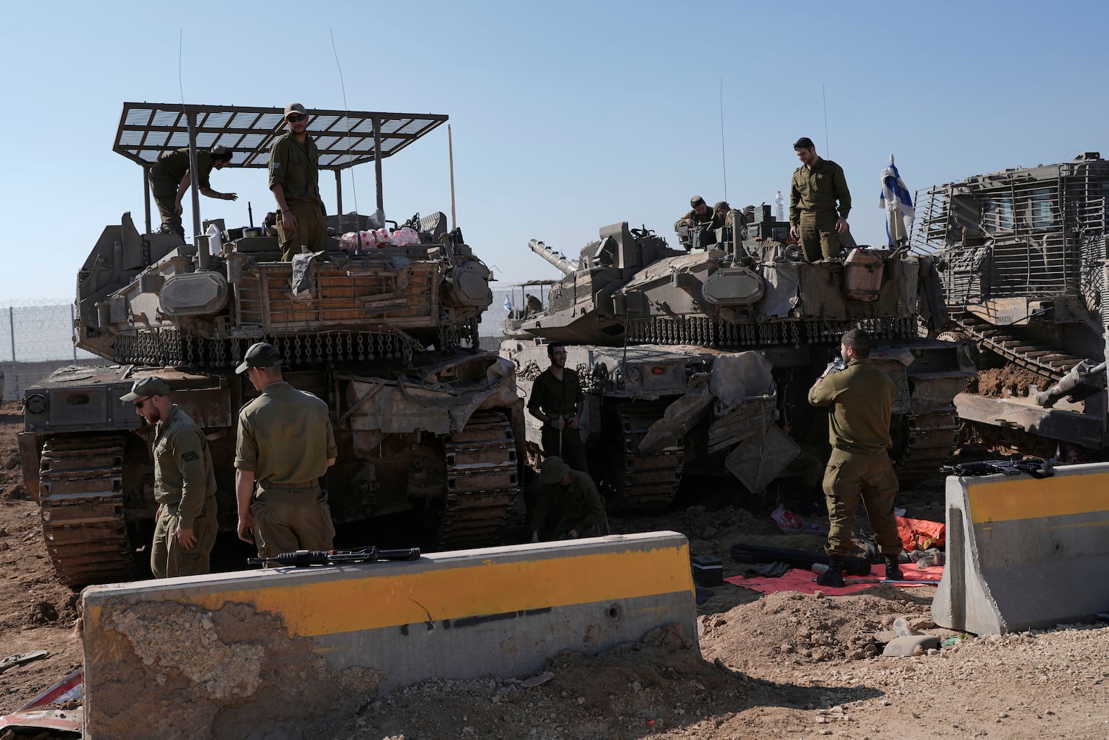 Israeli soldiers work in a staging area on the Israel-Gaza border after returning from the Gaza Strip, Saturday, Jan. 18, 2025, a day ahead of a ceasefire between Israel and Hamas. (AP Photo/Tsafrir Abayov)