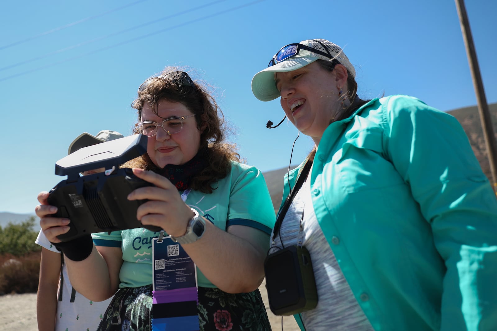 Grace Telfer, left, and Anita Marshall, a geoscience education researcher at the University of Florida, operate a drone allowing others to survey the San Andreas Fault during an accessible field trip organized by the International Association of Geoscience Diversity Thursday, Sept. 26, 2024, in San Bernadino, Calif. (AP Photo/Ryan Sun)