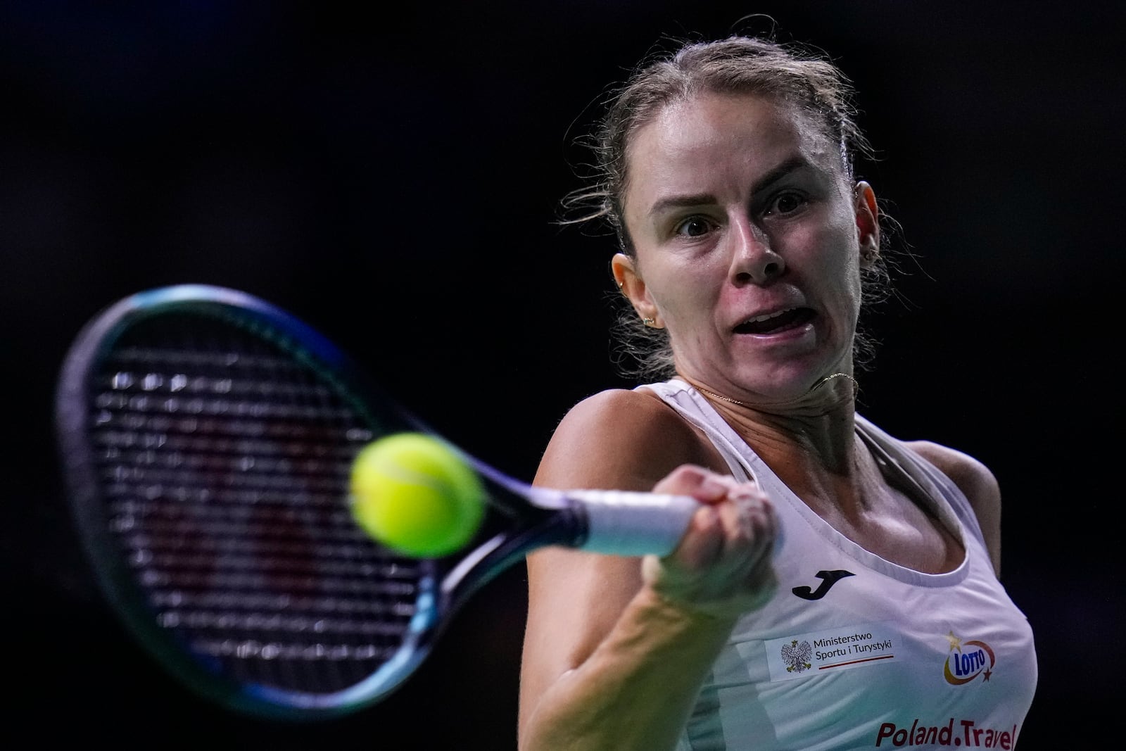 Poland's Magda Linette returns the ball against Spain's Sara Sorriber Tormo during the Billie Jean King Cup Finals, at the Martin Carpena Sports Hall, in Malaga, southern Spain, on Friday, Nov. 15, 2024. (AP Photo/Manu Fernandez)