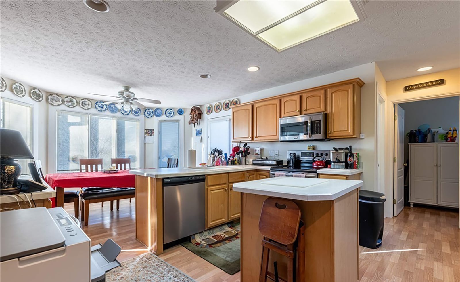 The eat in kitchen has tile flooring and wood cabinets and stainless appliances. It steps out to the wood deck.