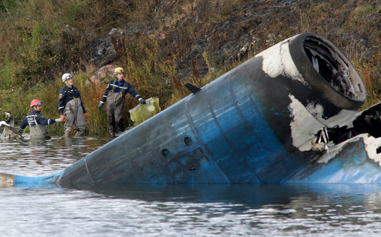 FILE - Rescuers work at the crash site of a Russian Yak-42 jet near the city of Yaroslavl, on the Volga River about 150 miles (240 kilometers) northeast of Moscow, Russia, Wednesday, Sept. 7, 2011. The Yak-42 jet, carrying members of the Lokomotiv ice hockey team from Yaroslavl, crashed while taking off. (AP Photo/Misha Japaridze, File)