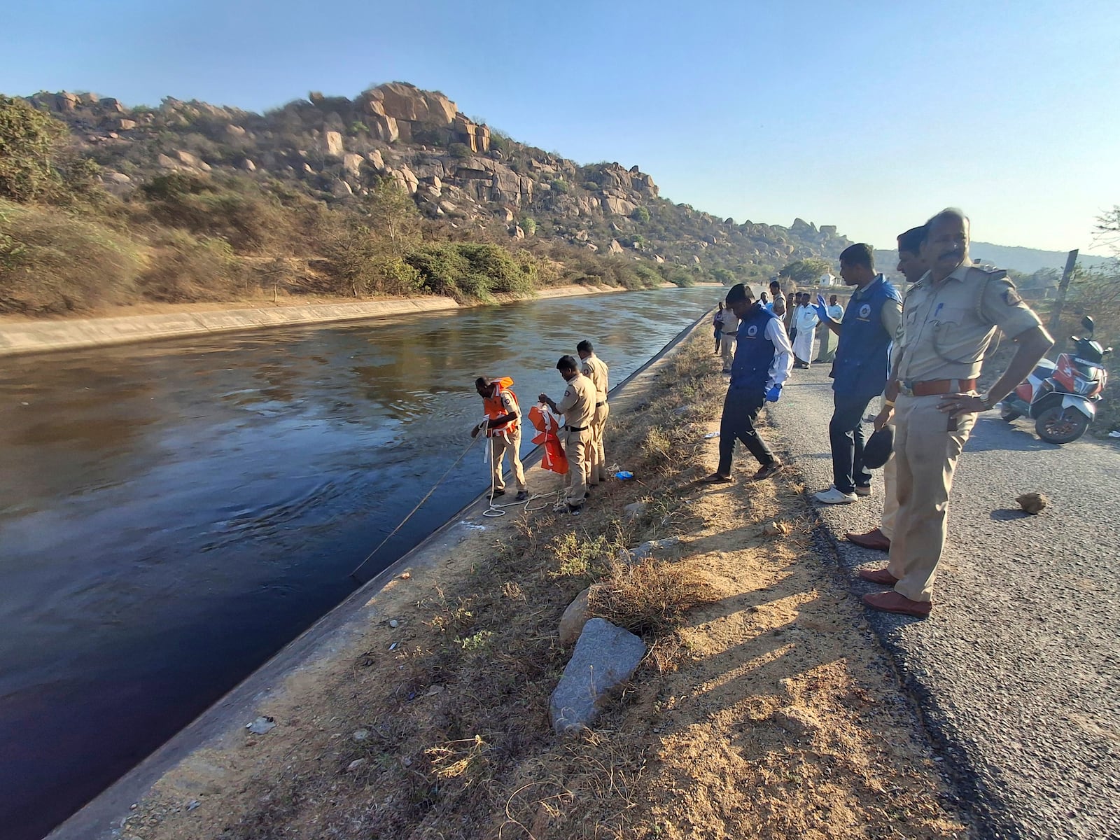 Police officials search for the male travelers who were pushed into the canal by three men accused of gang-raping two women, in Koppal district of southern state of Karnataka, India, Friday, March 7, 2025. (AP Photo)