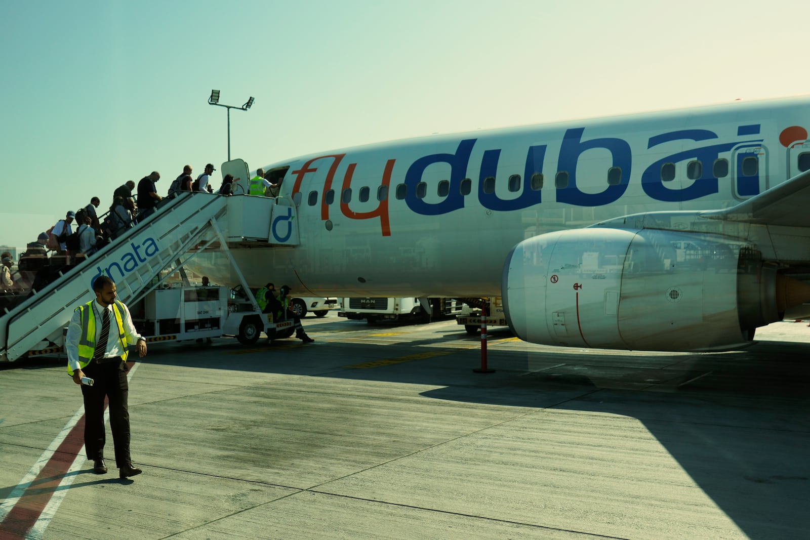 Passengers for a FlyDubai flight heading to Ben Gurion International Airport in Israel board their aircraft at Dubai International Airport in Dubai, United Arab Emirates, Friday, Oct. 18, 2024. (AP Photo/Jon Gambrell)