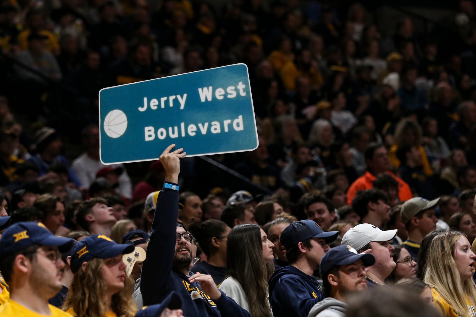 West Virginia fan holds up a Jerry West sign during the first half of an NCAA college basketball game, Saturday, Jan. 18, 2025, in Morgantown, W.Va. (AP Photo/William Wotring)