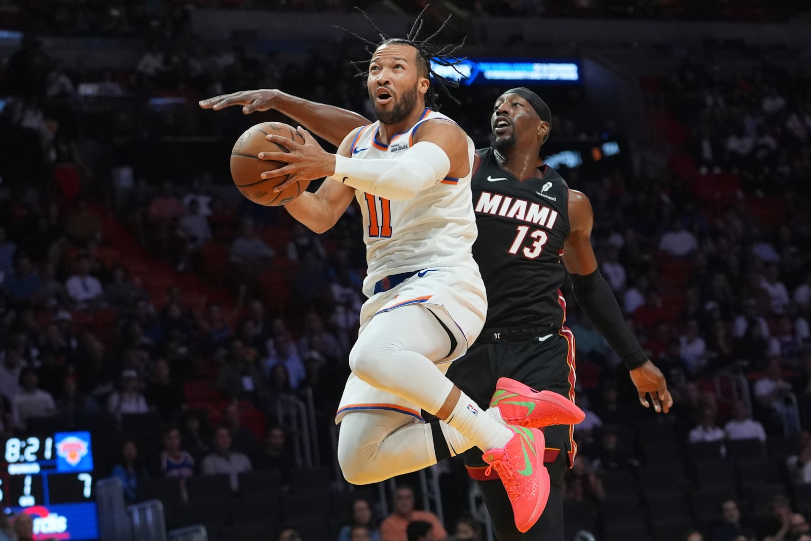 New York Knicks guard Jalen Brunson (11) goes to the basket as Miami Heat center Bam Adebayo (13) defends during the first half of an NBA basketball game, Wednesday, Oct. 30, 2024, in Miami. (AP Photo/Lynne Sladky)