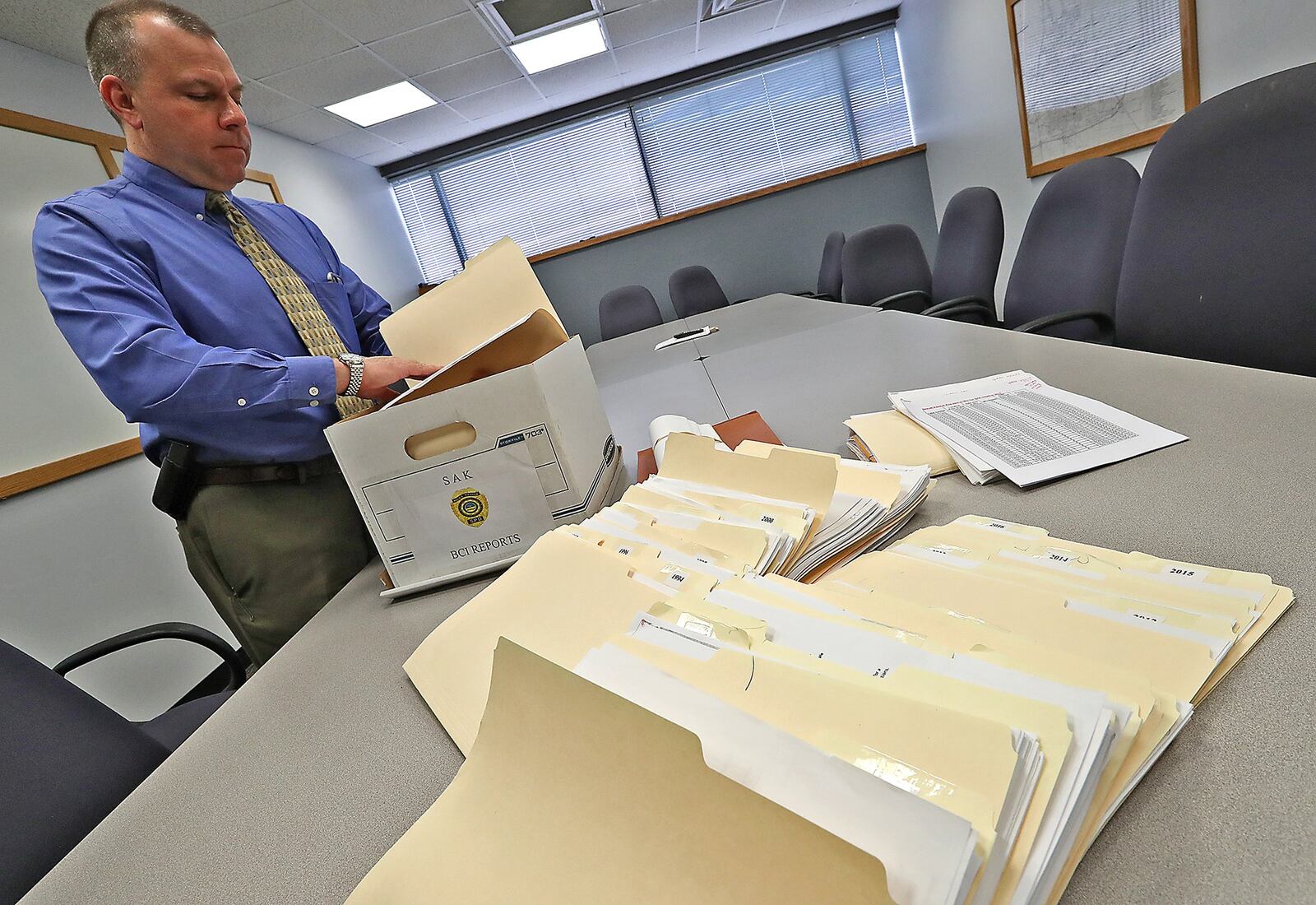 Sgt. Joe Tedeschi, a detective with the Springfield Police Division, looks over sexual assualt cases dating back to 1992. Bill Lackey/Staff