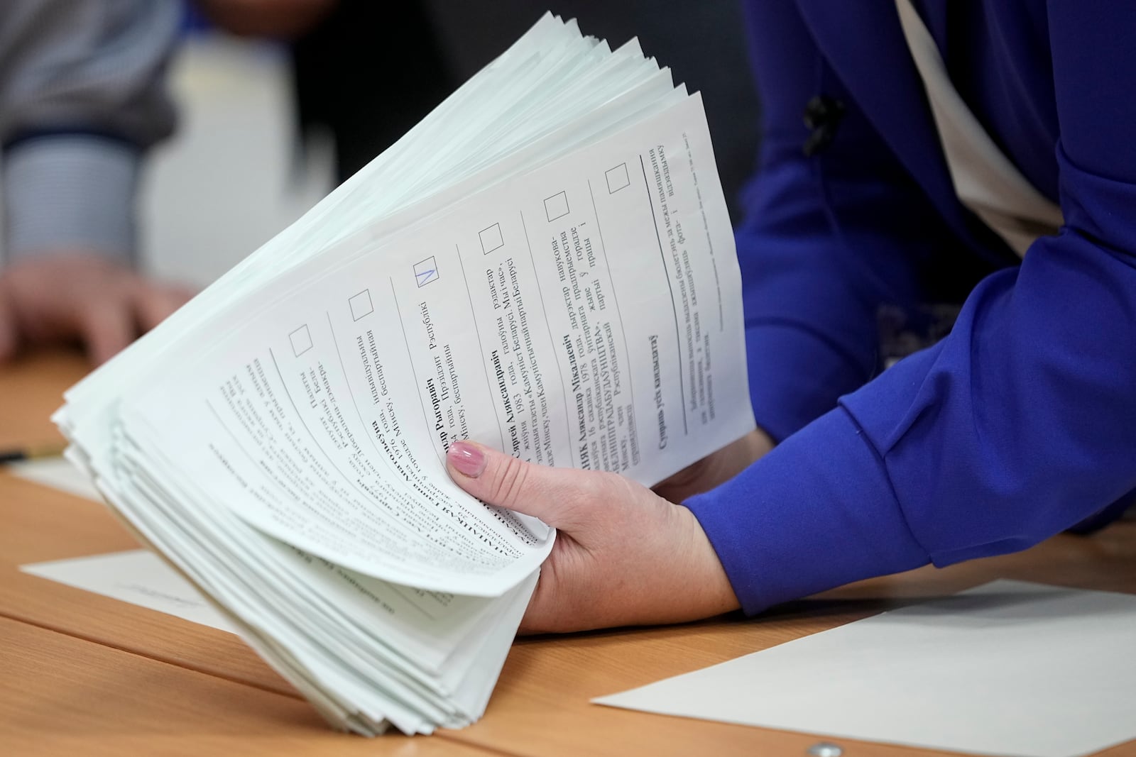 An Election commission member holds ballots after voting for presidential election at a polling station in Minsk, Belarus, Sunday, Jan. 26, 2025. (AP Photo/Pavel Bednyakov)