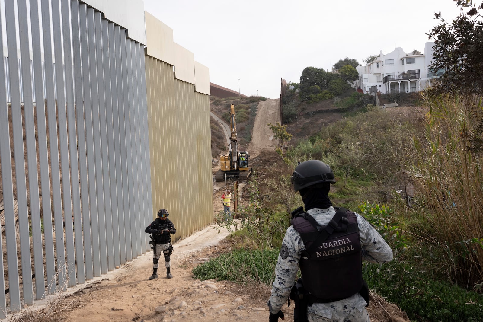 Members of the Mexican National Guard patrol as construction crews replace sections of one of two border walls separating Mexico from the United States, Wednesday, Jan. 22, 2025, in Tijuana, Mexico. (AP Photo/Gregory Bull)