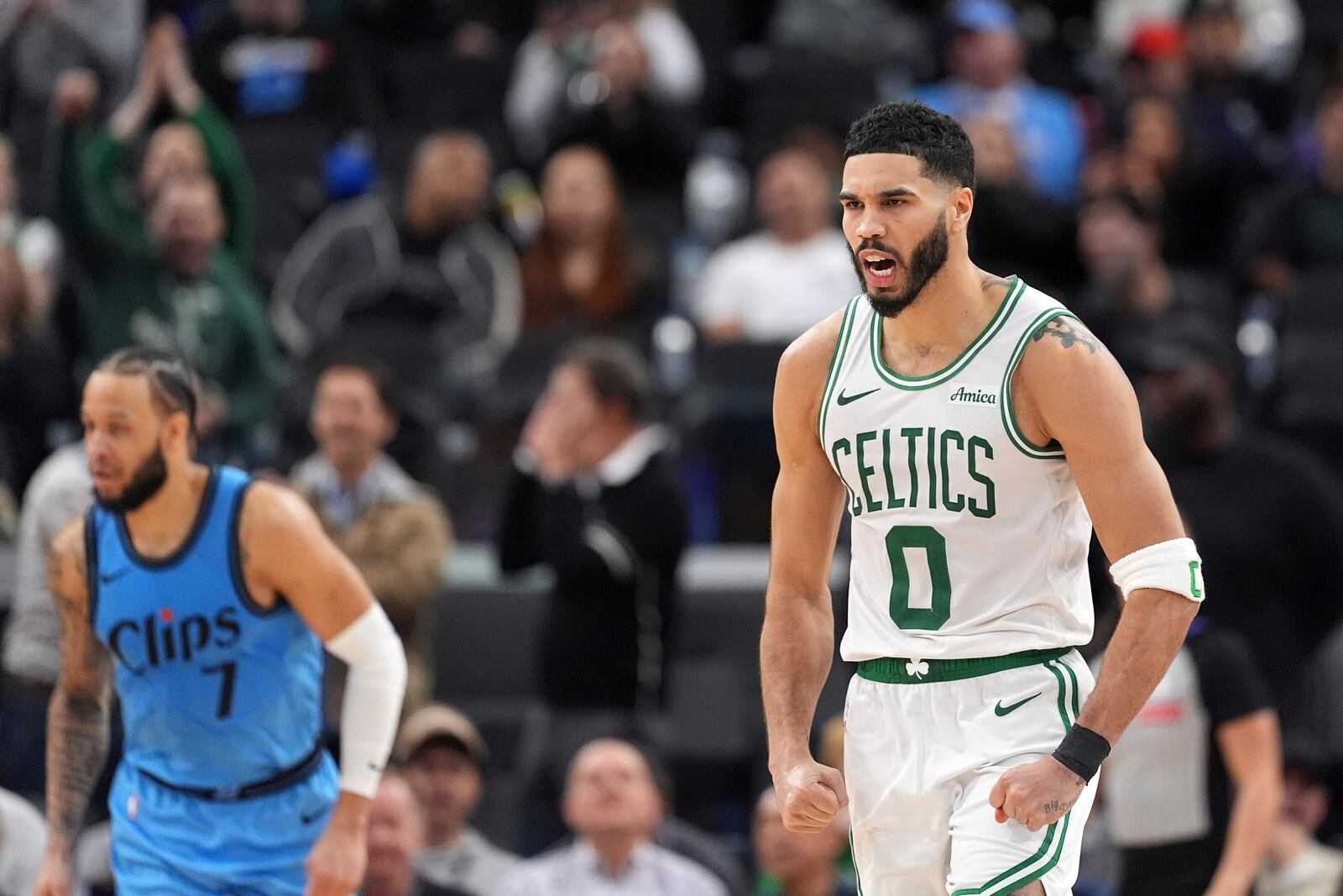 Boston Celtics forward Jayson Tatum, right, celebrates after hitting a three-point shot as Los Angeles Clippers guard Amir Coffey stands by during the second half of an NBA basketball game, Wednesday, Jan. 22, 2025, in Inglewood, Calif. (AP Photo/Mark J. Terrill)