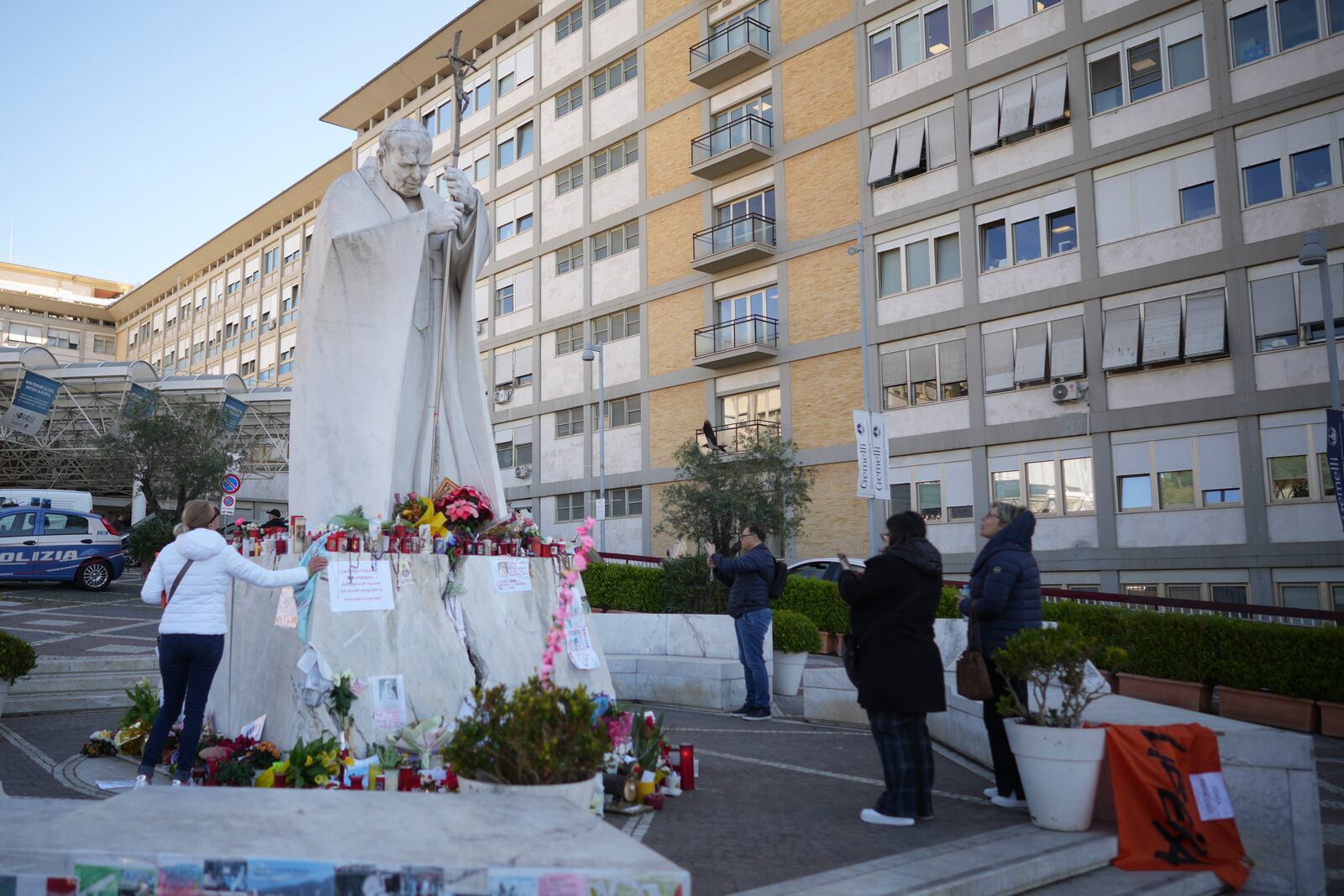 People pray for Pope Francis in front of the Agostino Gemelli Polyclinic, in Rome, Tuesday, March 18, 2025, where the Pontiff is hospitalized since Feb. 14. (AP Photo/Andrew Medichini)