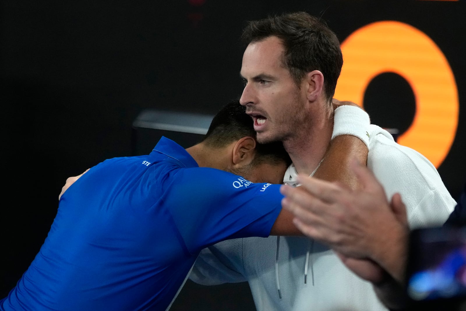 Novak Djokovic of Serbia celebrates with coach Andy Murry, right, after defeating Carlos Alcaraz of Spain in their quarterfinal match at the Australian Open tennis championship in Melbourne, Australia, early Wednesday, Jan. 22, 2025. (AP Photo/Asanka Brendon Ratnayake)