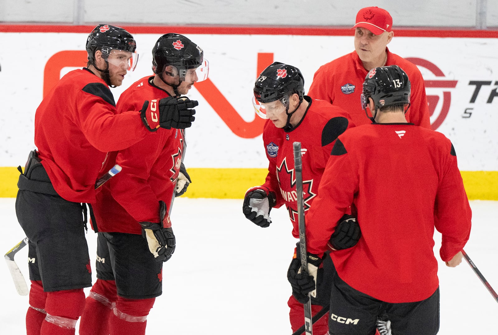 Canada's Connor McDavid, left, speaks with Sidney Crosby, second from left, as they work drills with teammates Nathan MacKinnon, third from left, and Sam Reinhart (13) during a 4 Nations Face-Off hockey practice in Brossard, Quebec, Monday, Feb. 10, 2025. (Christinne Muschi/The Canadian Press via AP)