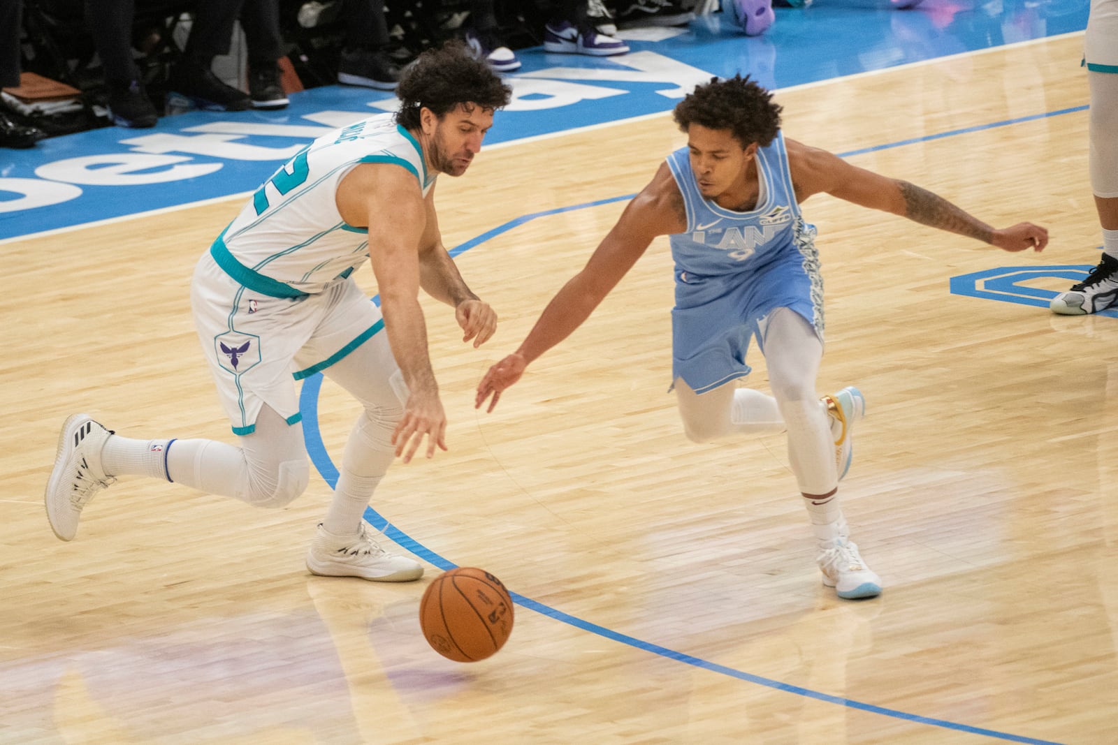 Charlotte Hornets' Vasilije Micic, left, and Cleveland Cavaliers' Craig Porter Jr., right, go for the ball during the first half of an NBA basketball game in Cleveland, Sunday, Nov 17, 2024. (AP Photo/Phil Long)