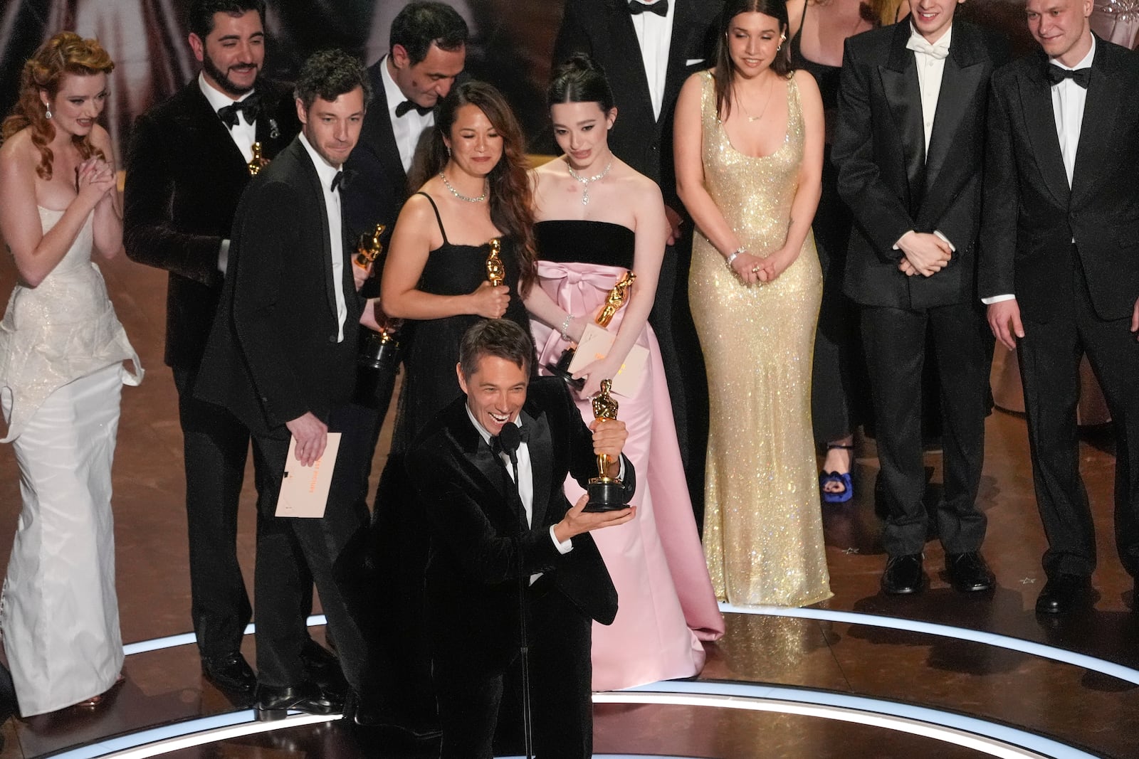 Lindsey Normington, from left, Alex Coco, Vache Tovmasyan, Sean Baker, Samantha Quan, Karren Karagulian Mikey Madison, Drew Daniels, Luna Sofía Miranda, Mark Eydelshteyn, and Yura Borisov accept the award for best picture for "Anora" during the Oscars on Sunday, March 2, 2025, at the Dolby Theatre in Los Angeles. (AP Photo/Chris Pizzello)