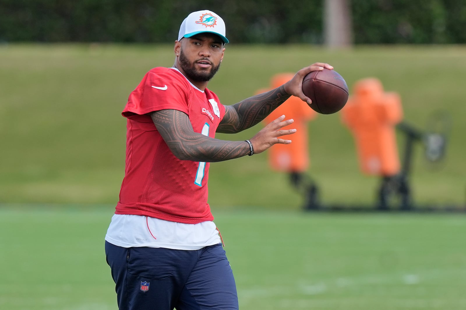 Miami Dolphins quarterback Tua Tagovailoa (1) aims the ball during a practice session at the team's training facility, Wednesday, Oct. 23, 2024, in Miami Gardens, Fla. (AP Photo/Marta Lavandier)