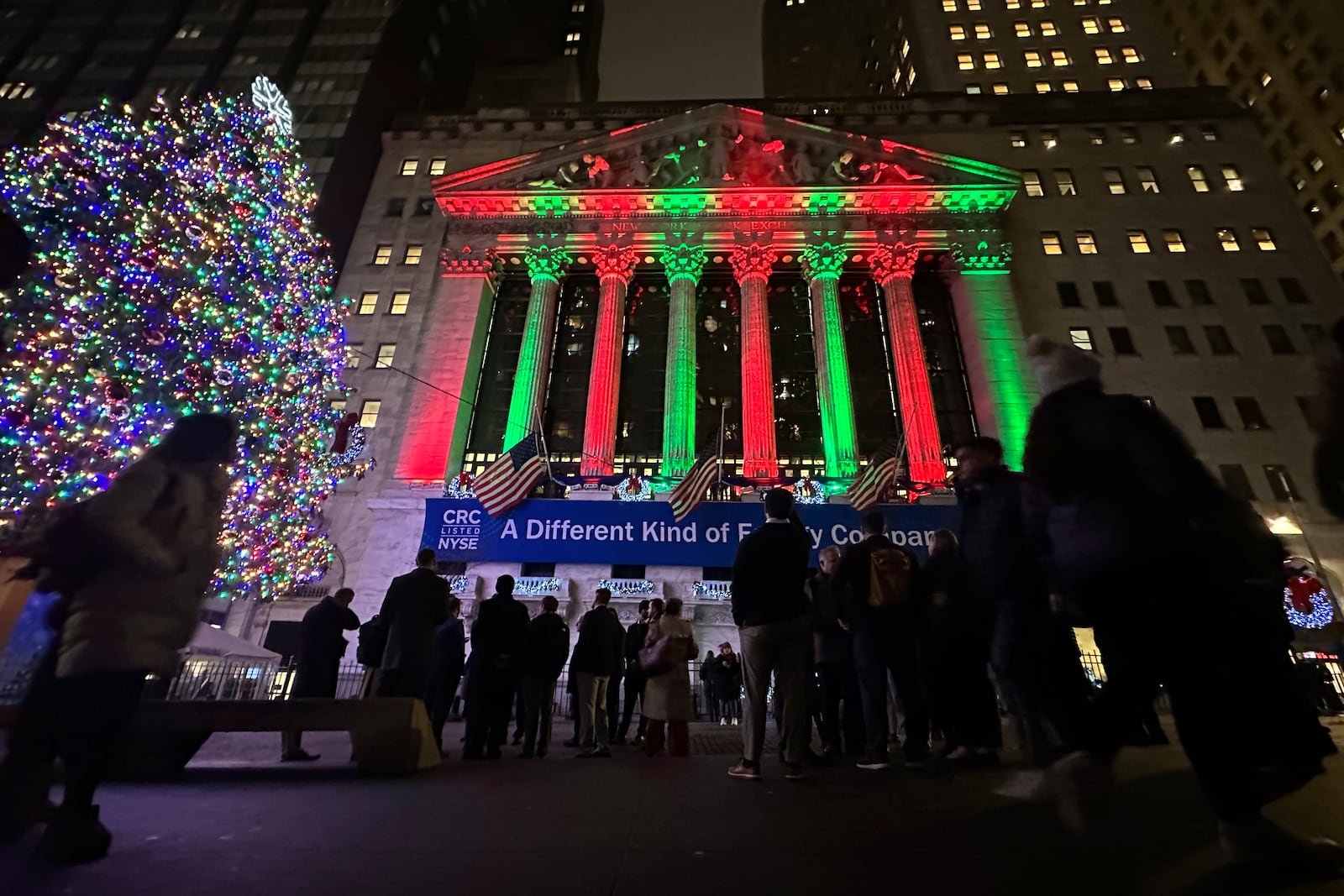 People gather in front of the New York Stock Exchange in New York's Financial District on Tuesday, Dec. 10, 2024. (AP Photo/Peter Morgan)